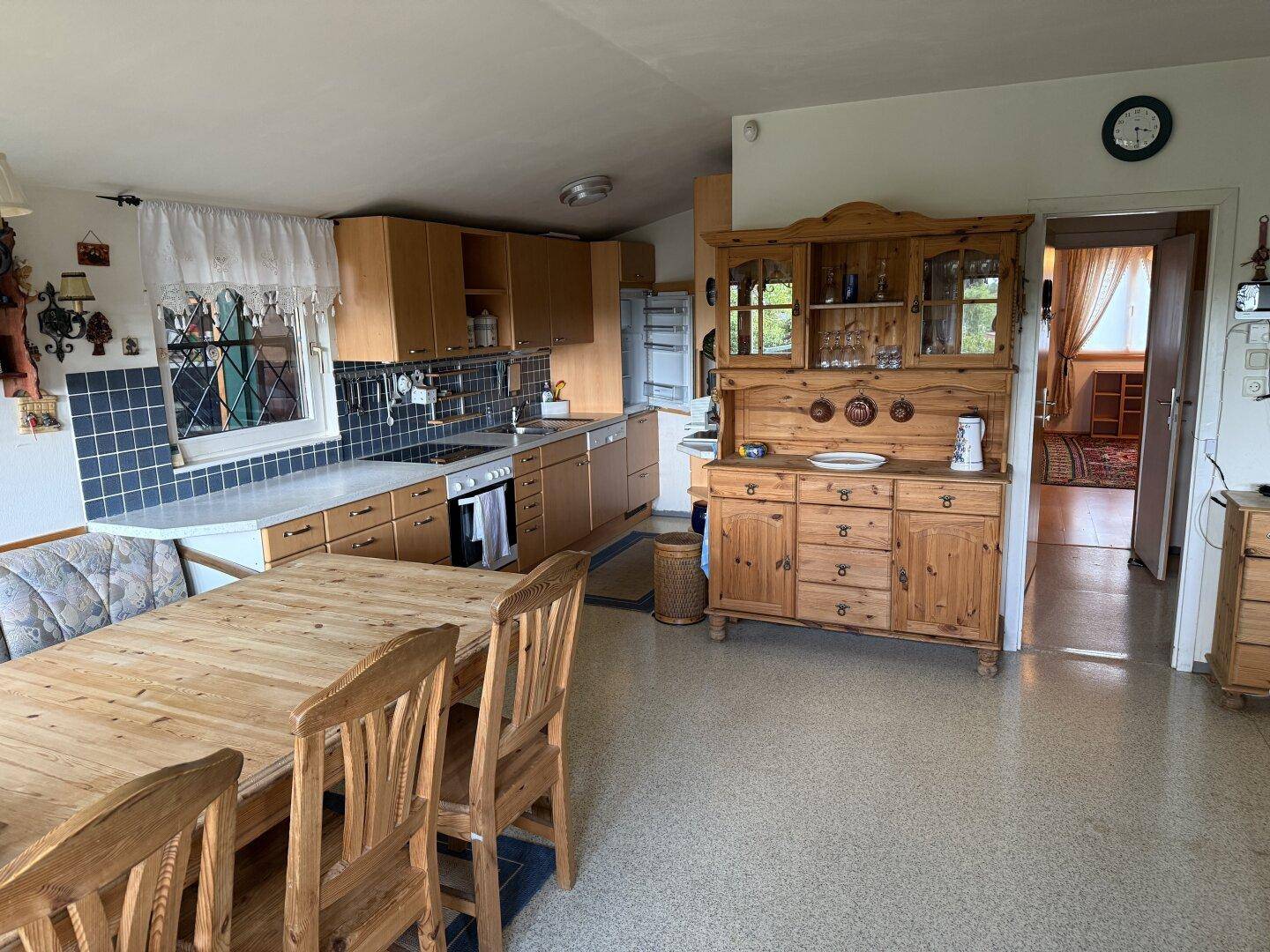 Traditionelle Küche mit Holztisch, blauen Fliesen und Holzschränken.