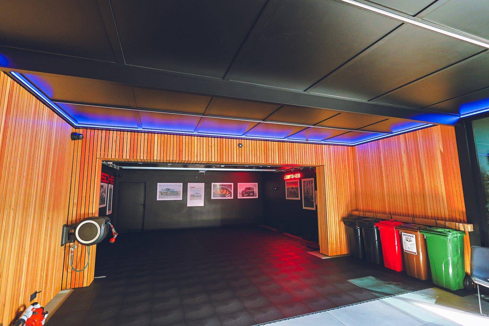 Geräumige Garage mit Holzverkleidung, LED-Beleuchtung und Mülltrennsystem.