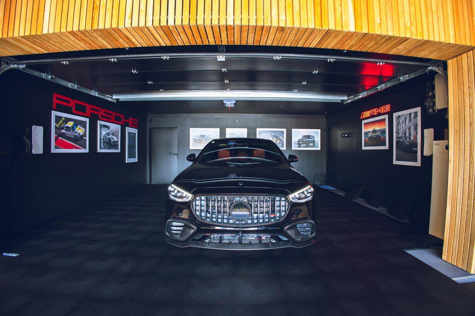 Exklusive Garage mit einem Luxusauto und thematischer Wanddekoration.