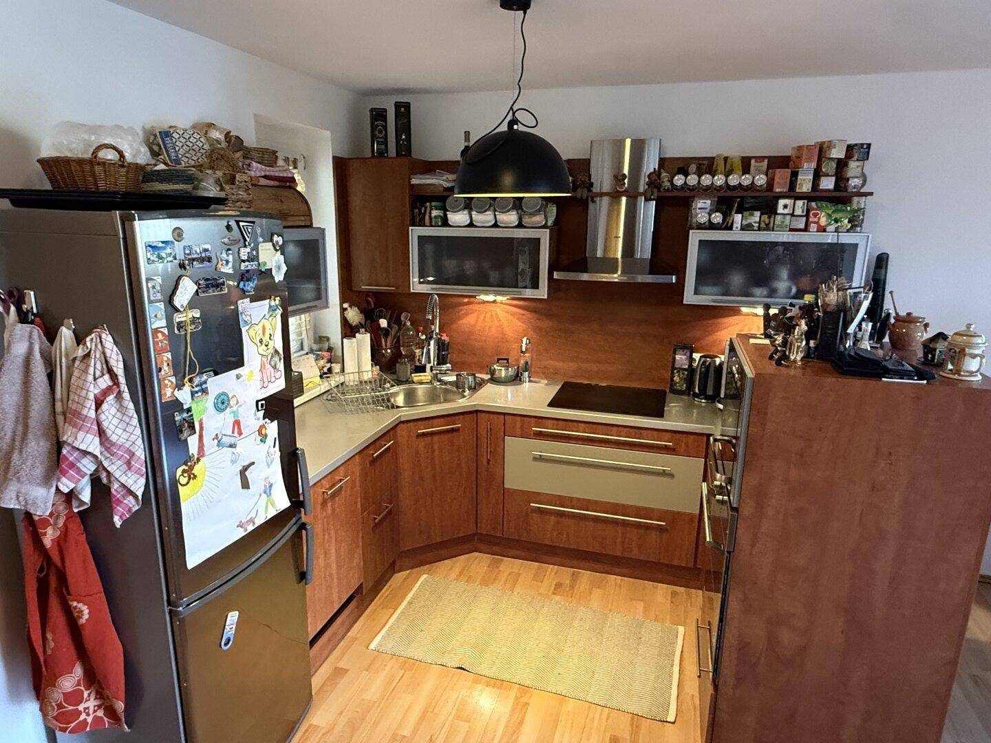 Funktionale Küche mit Holzfronten, Einbaugeräten und ausreichend Stauraum.