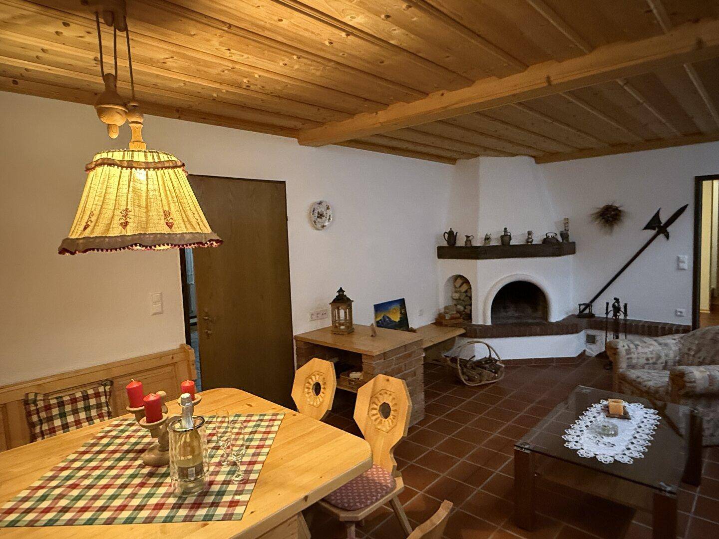 Rustikaler Wohnbereich im Keller mit Kamin, Holzbalkendecke und traditioneller Einrichtung.