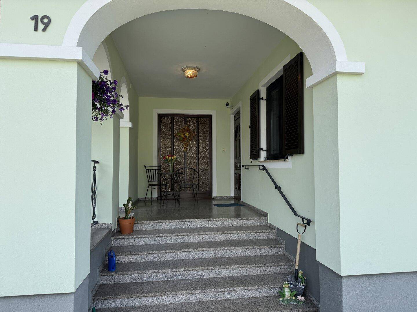 Eingangsbereich des Hauses mit Granittreppe, Bogen und Hausnummer 19.