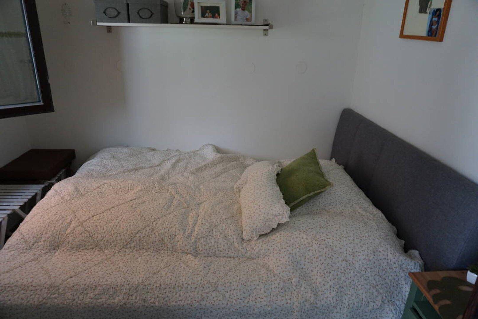 Schlafzimmer mit Doppelbett und schlichter, heller Bettwäsche, einladend gestaltet.