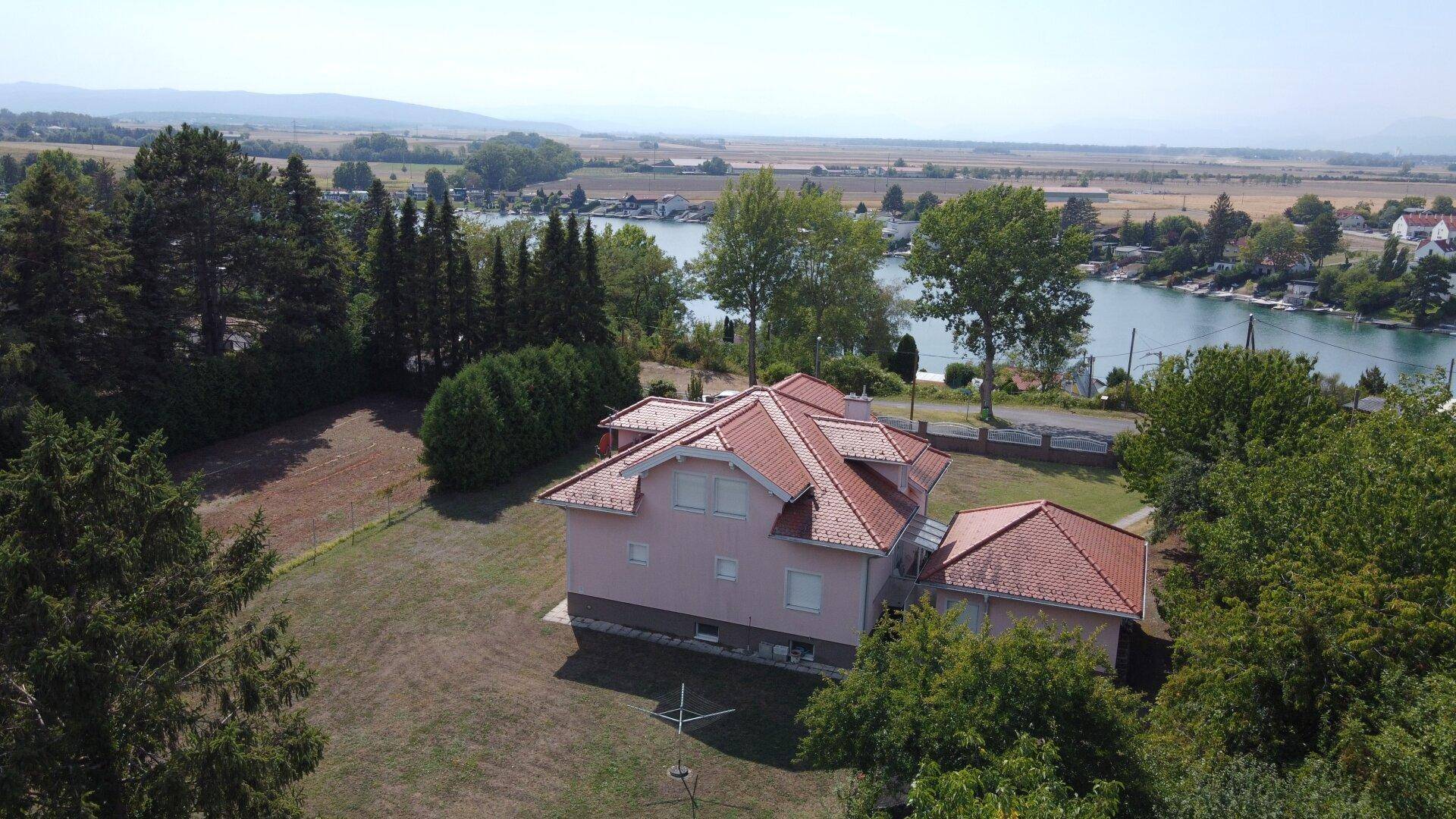 Luftaufnahme des Hauses mit Blick auf den See und die umliegende Landschaft.
