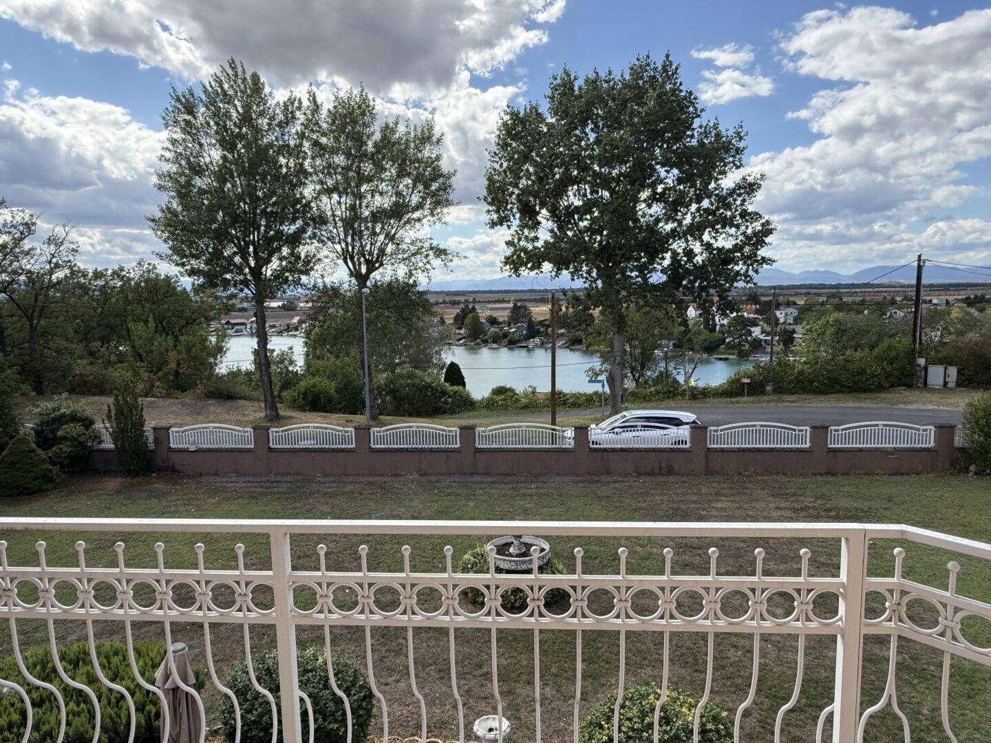 Panoramablick vom Balkon auf den See und die umliegende Berglandschaft.