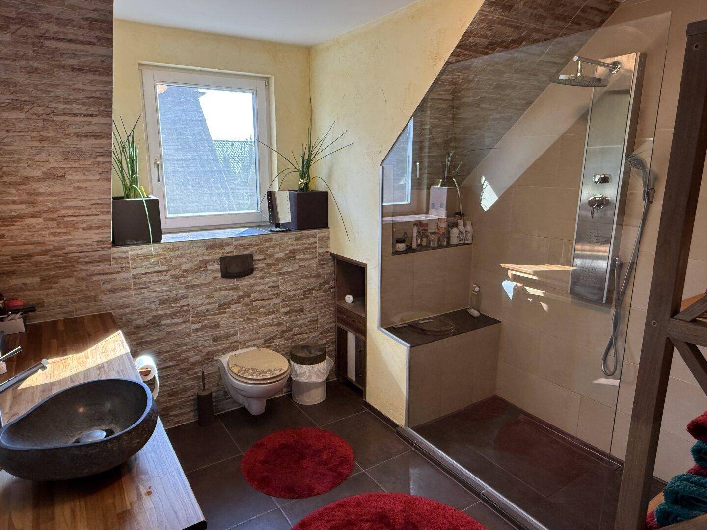 Modernes Badezimmer mit begehbarer Dusche, Steinwaschbecken und Dachschräge.