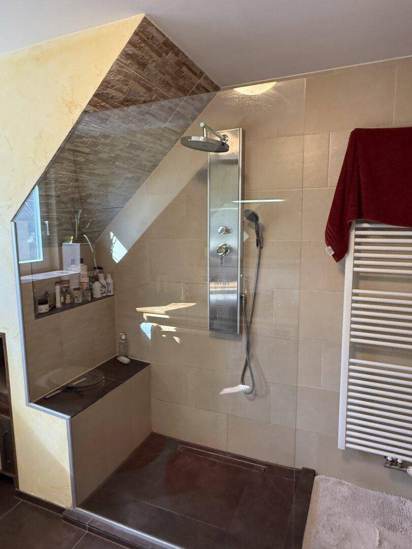 Geräumige begehbare Dusche mit Regenduschkopf und modernen Armaturen in einem Badezimmer.