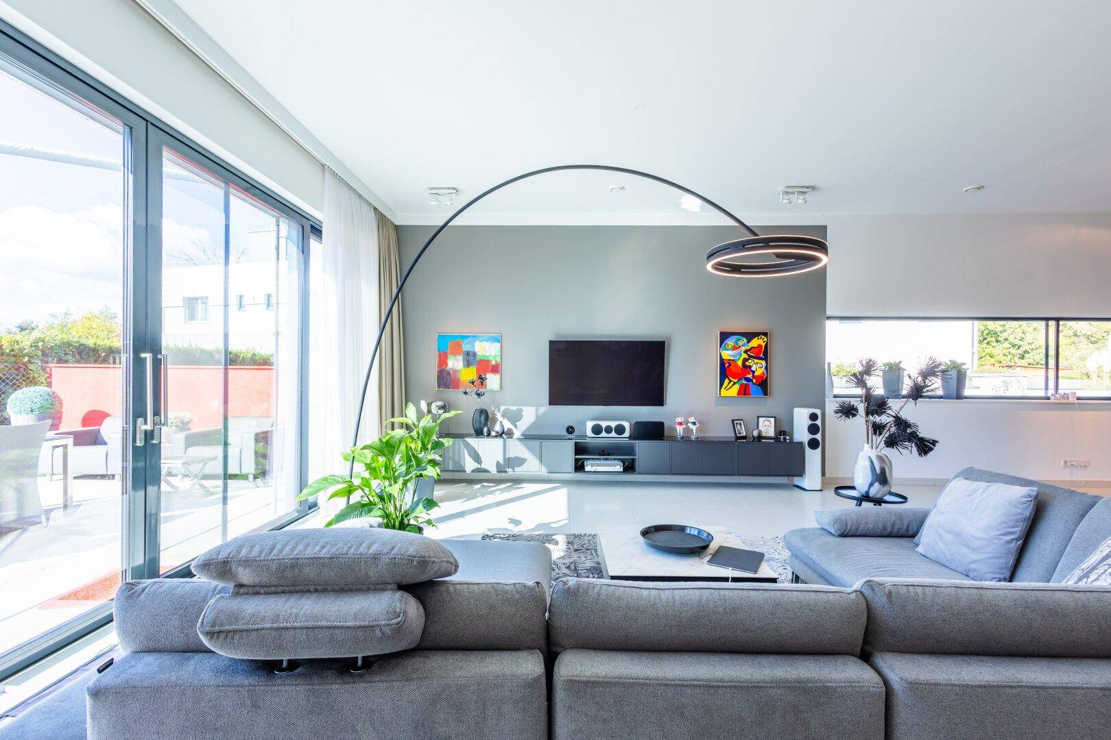 Helles Wohnzimmer mit großzügigen Schiebetüren zur Terrasse und moderner Einrichtung.