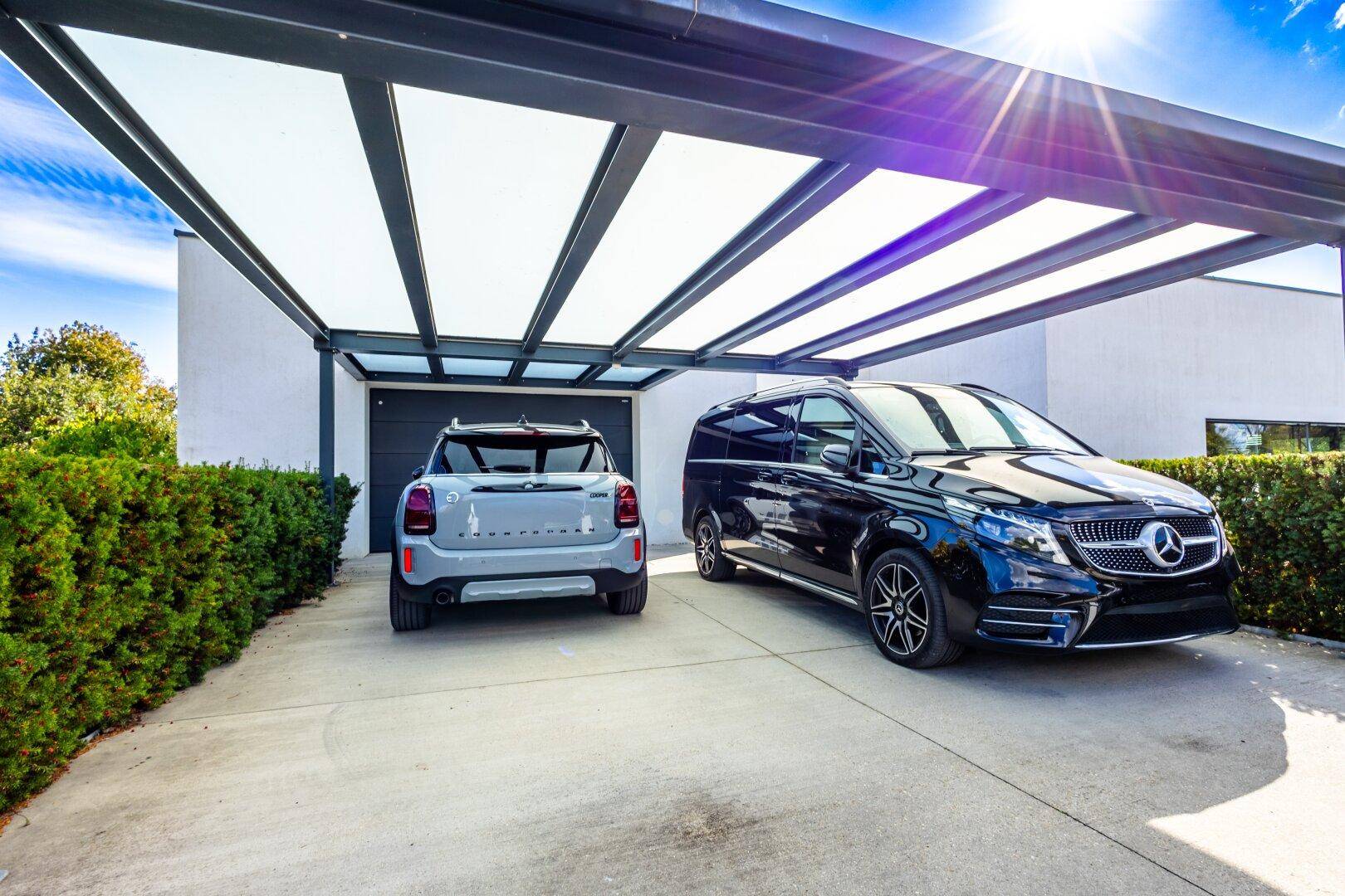 Überdachter Carport mit Stellplätzen für zwei Fahrzeuge vor dem modernen Haus.