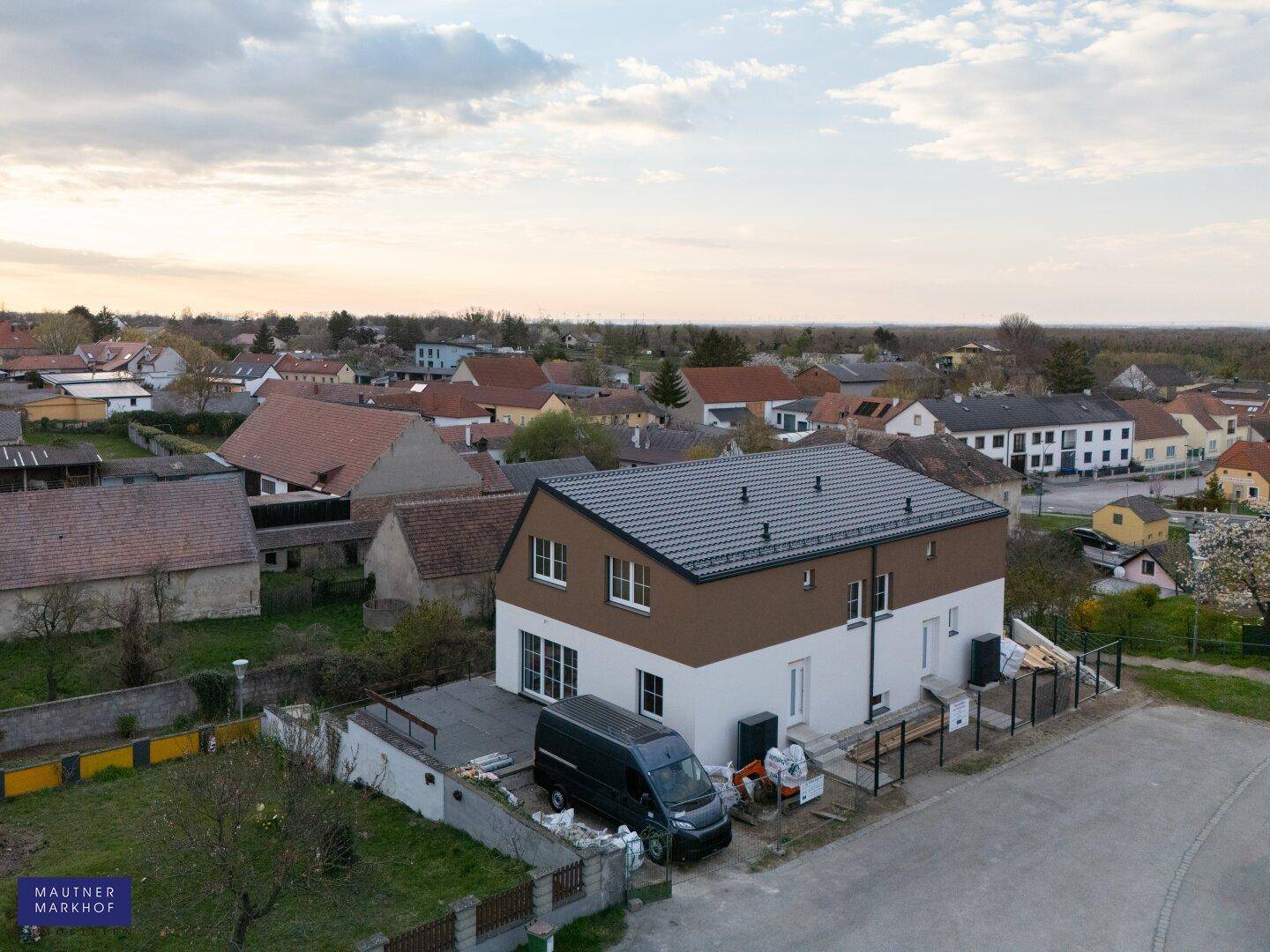 Luftaufnahme des Hauses von hinten mit angrenzendem Grundstück und Blick auf die Nachbarschaft.