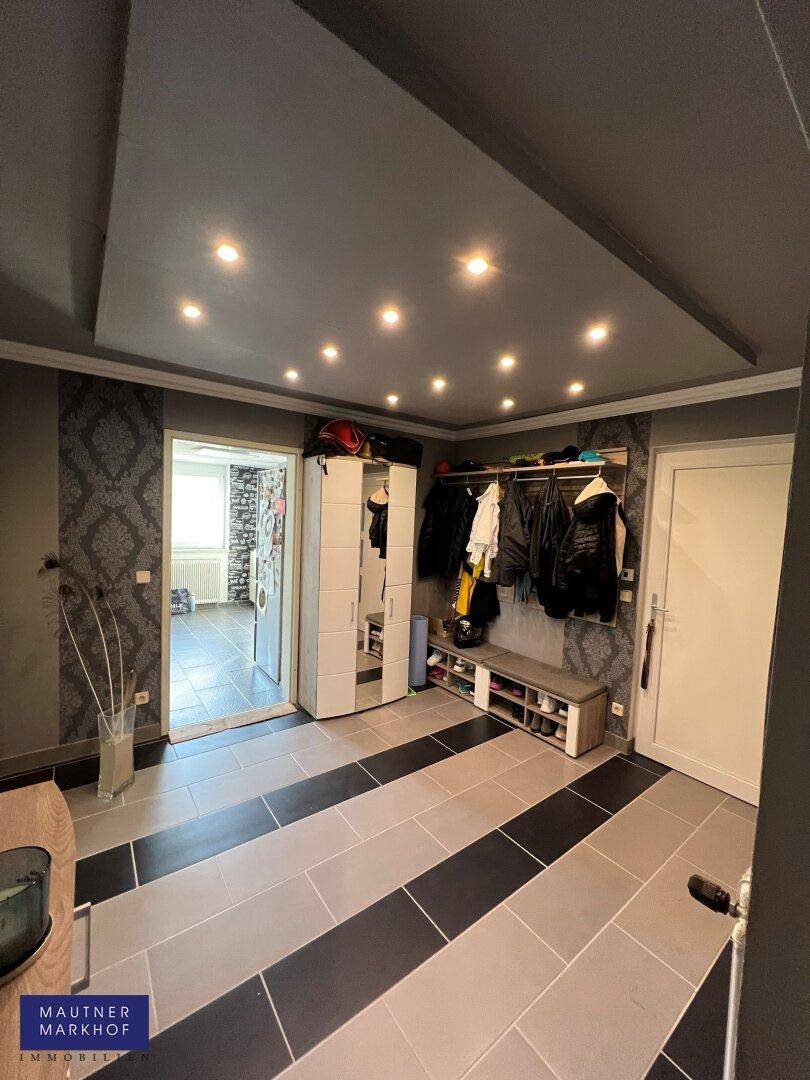 Eingangsbereich mit Garderobe, Einbauschränken und moderner Beleuchtung.