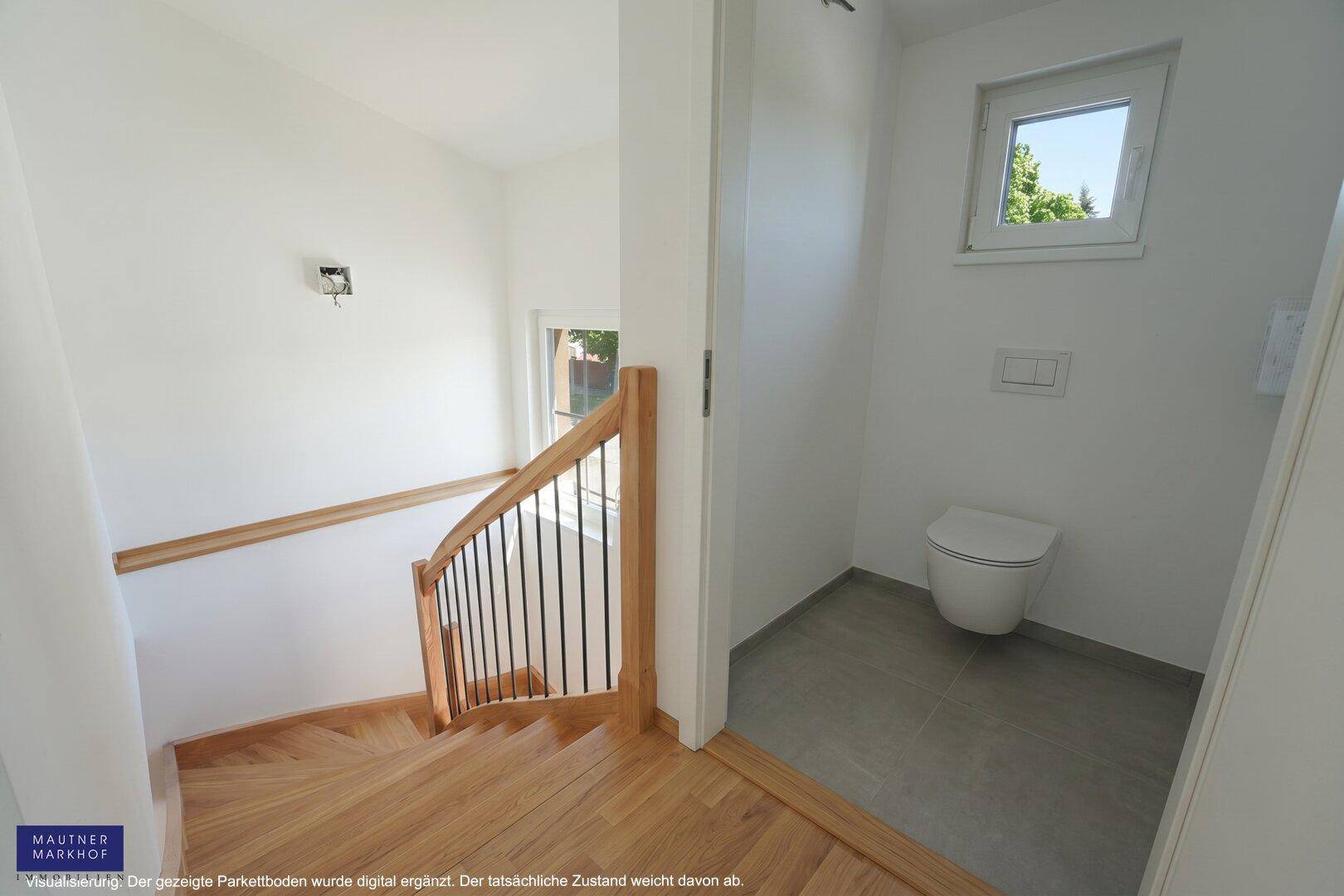 Heller Treppenbereich mit Holztreppe und angrenzendem Gäste-WC mit Fenster.