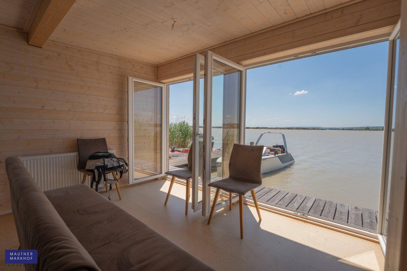 Wohnbereich mit Panoramafenstern bietet einen atemberaubenden Blick auf den See.