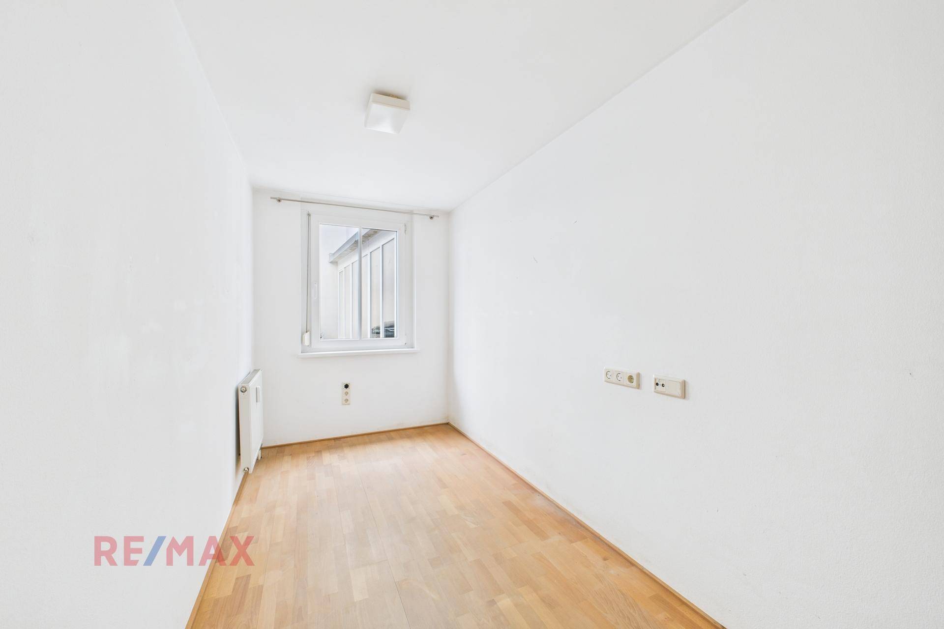 Kleiner, heller Raum mit Fenster und Holzboden, ideal als Büro oder Kinderzimmer.