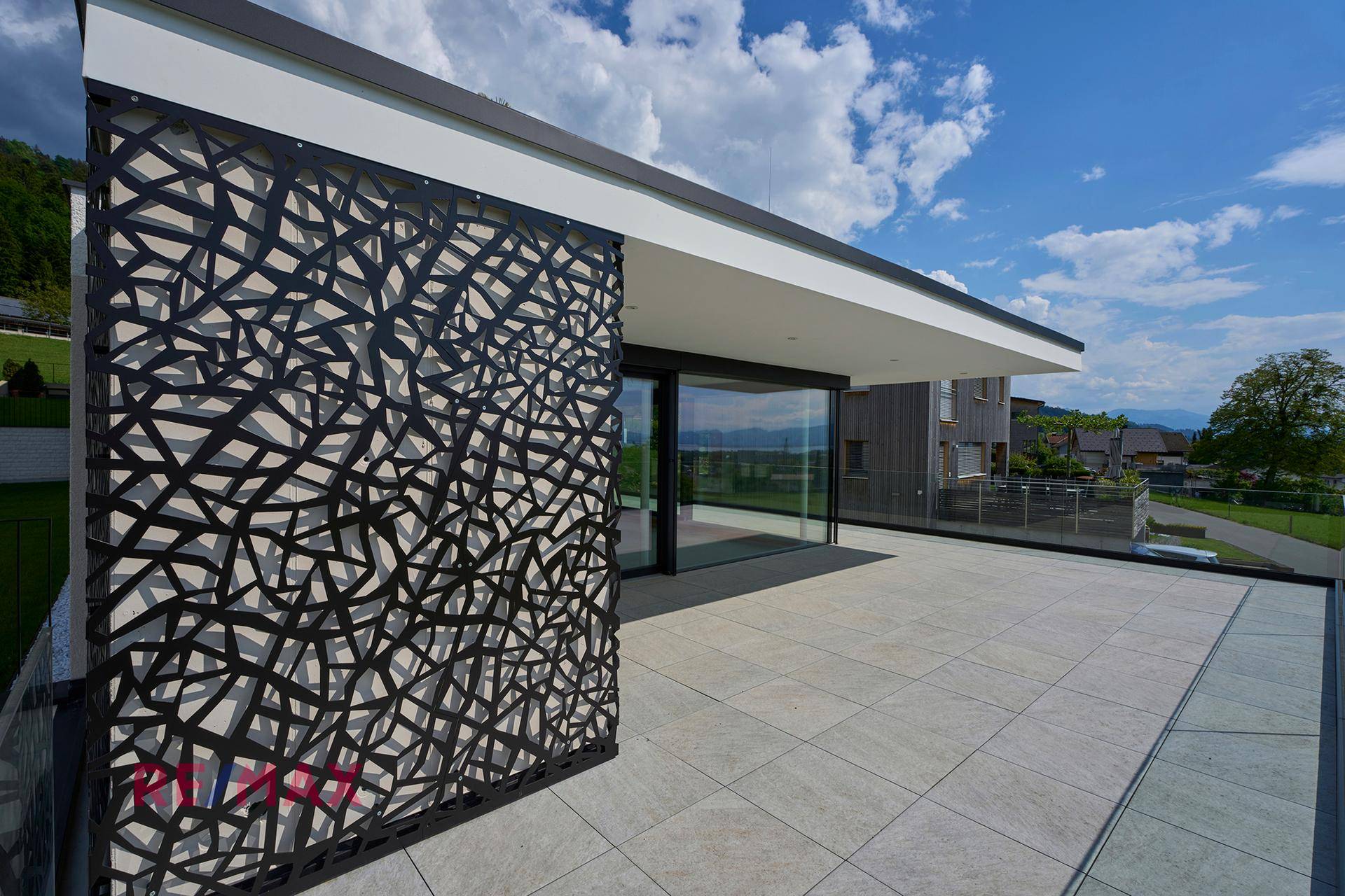 Geräumige Terrasse mit modernem Sichtschutz und weitem Blick auf die umliegende Natur.