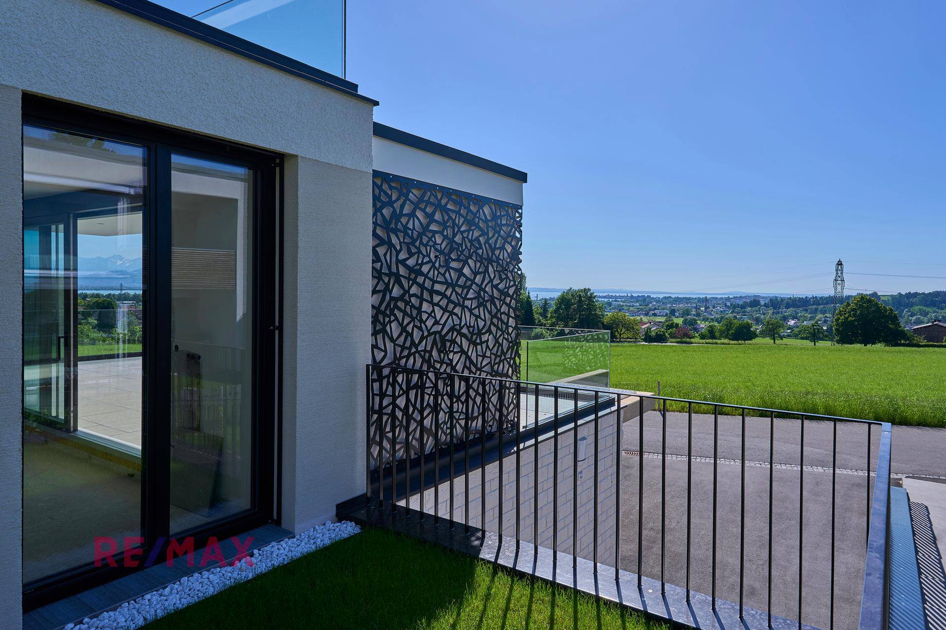 Kleiner Balkon mit Metallgeländer und Blick auf die grüne Landschaft.