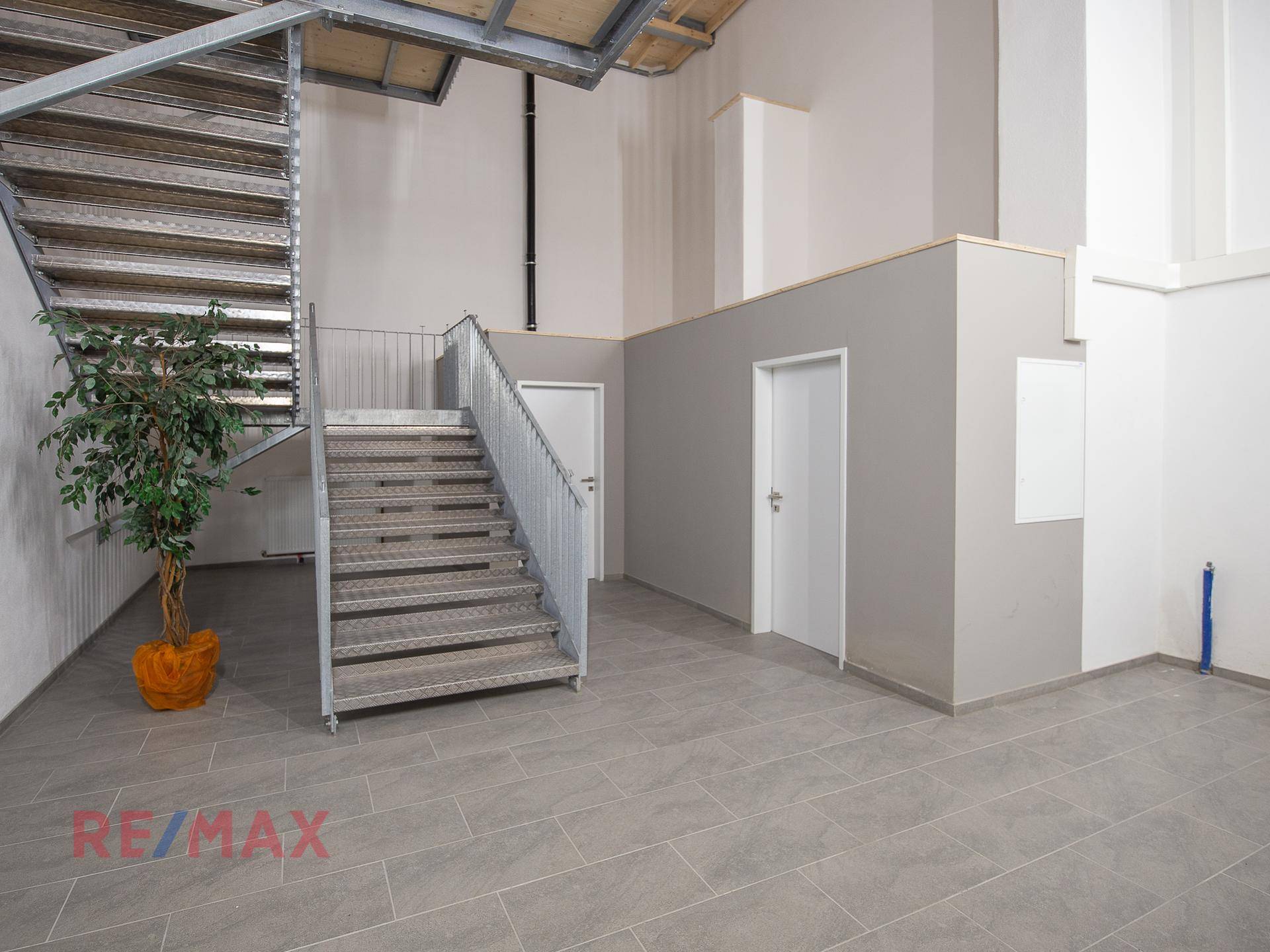Geräumiger Flur mit einer robusten Metalltreppe und mehreren Türen, die zu weiteren Räumen führen.