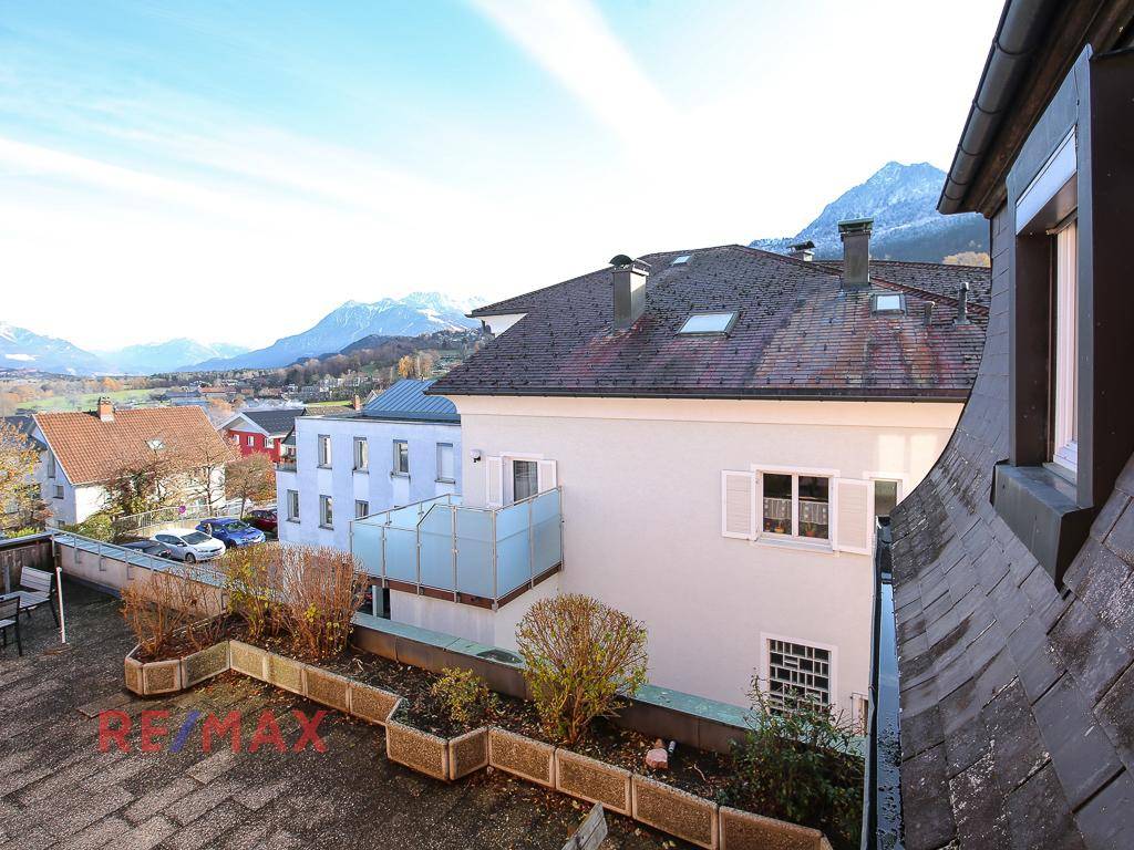 Große Dachterrasse mit Pflanzkübeln und weitem Blick auf die Berge.