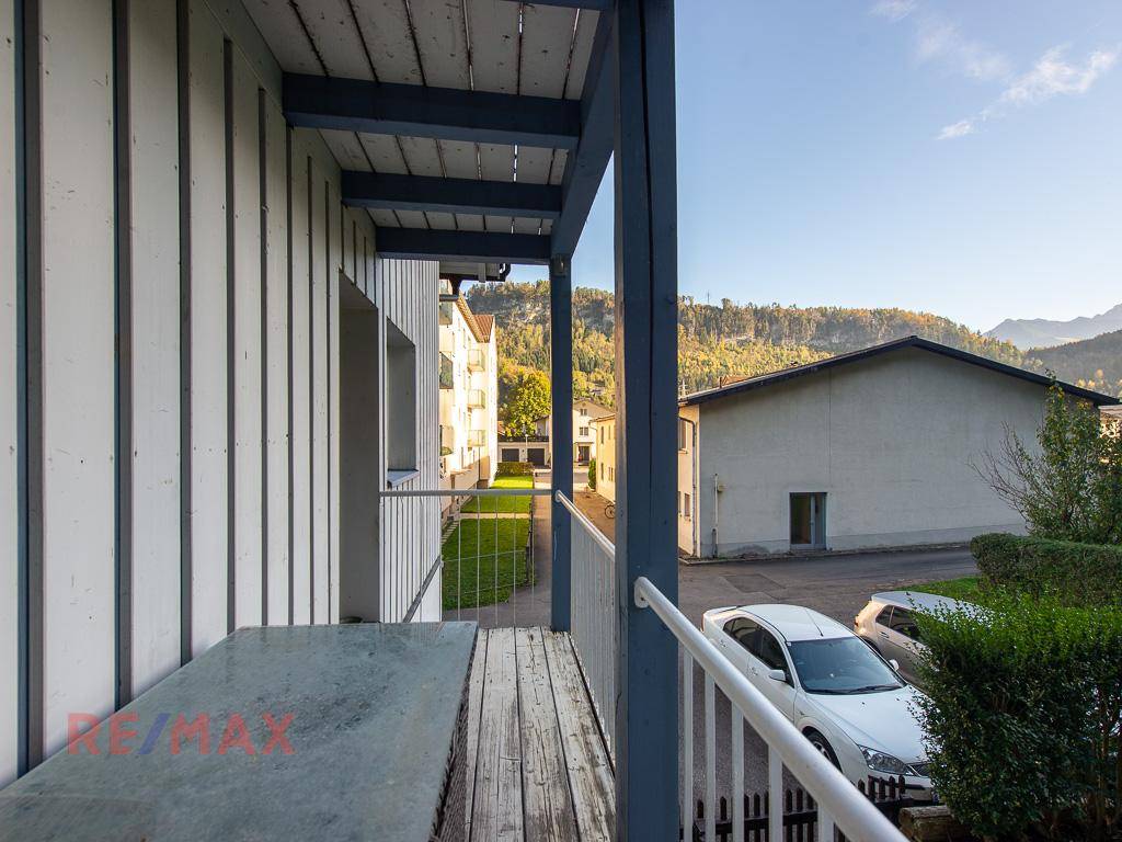 Balkon mit Holzboden und Blick auf die umliegende Landschaft und Parkplätze.