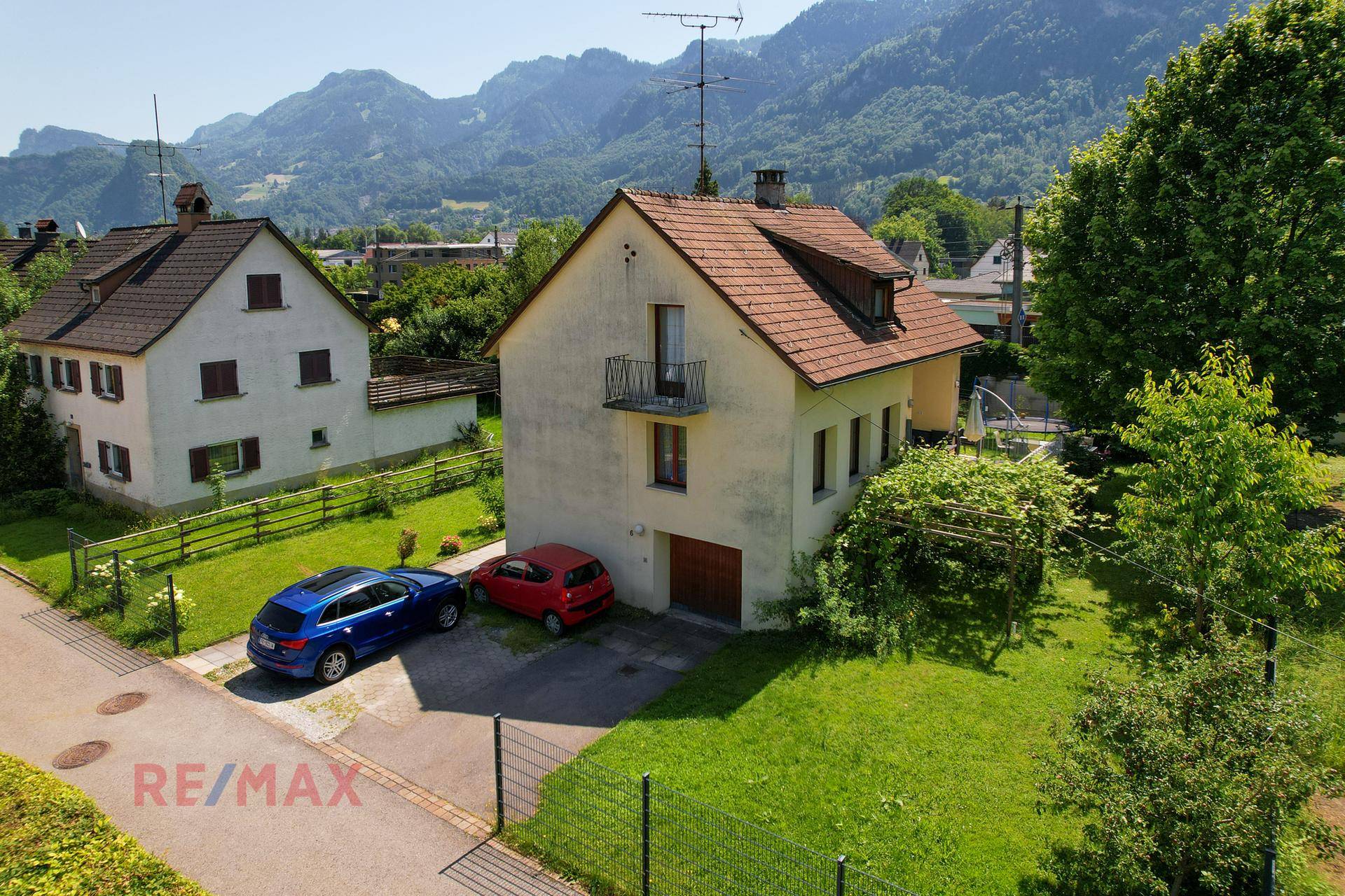 Vorderansicht des Einfamilienhauses mit Garage, Stellplätzen und einem gepflegten Vorgarten.