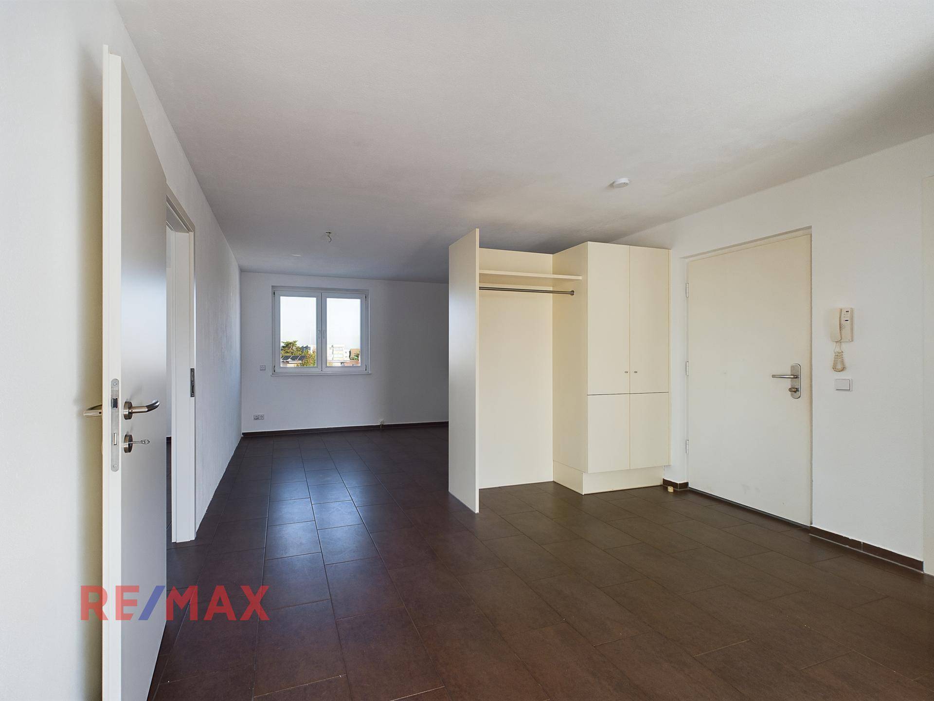 Eingangsbereich mit Fliesenboden und praktischem Einbauschrank für Kleidung.
