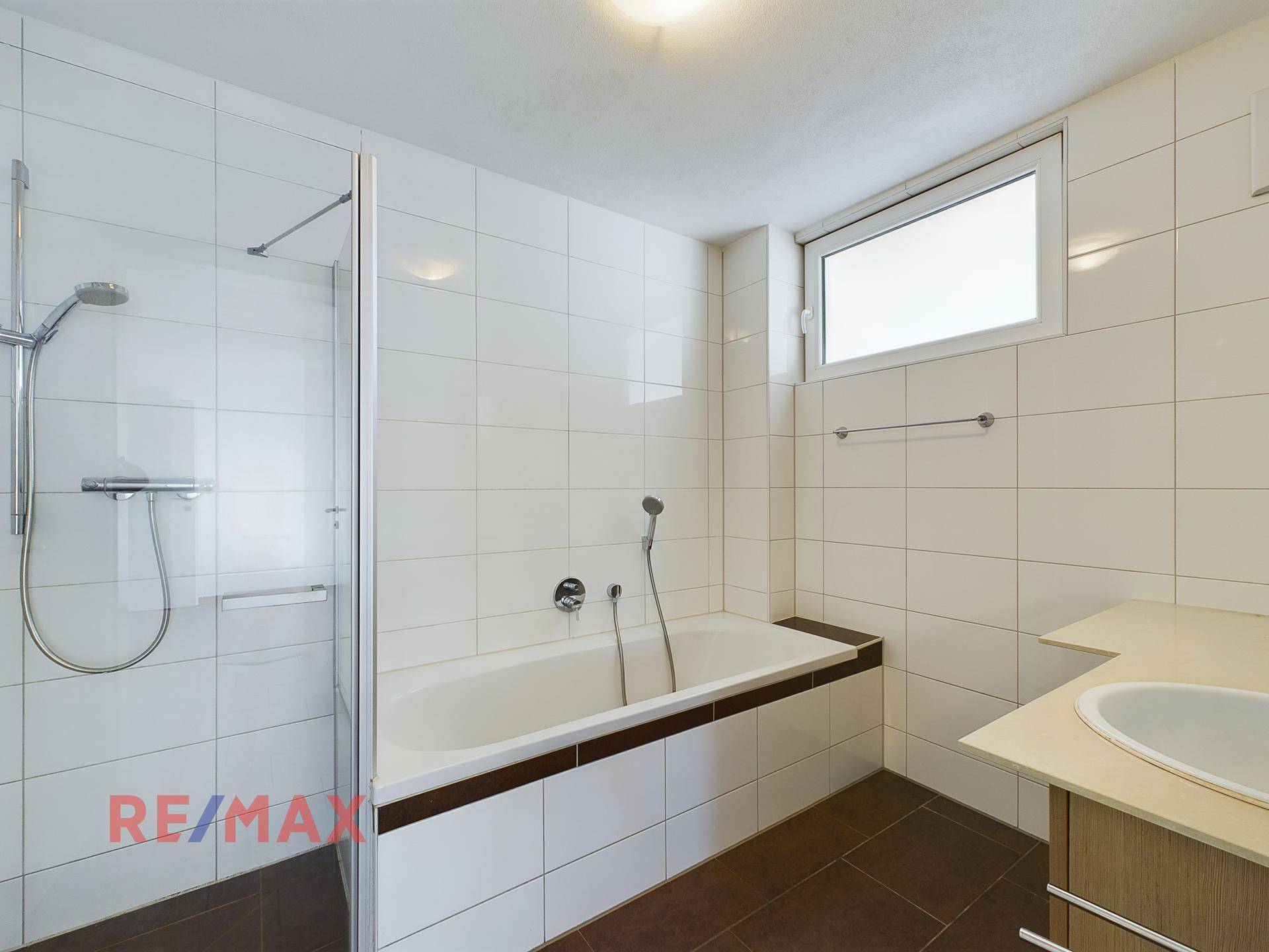 Badezimmer mit Badewanne, Duschkabine und Fenster für Belüftung.