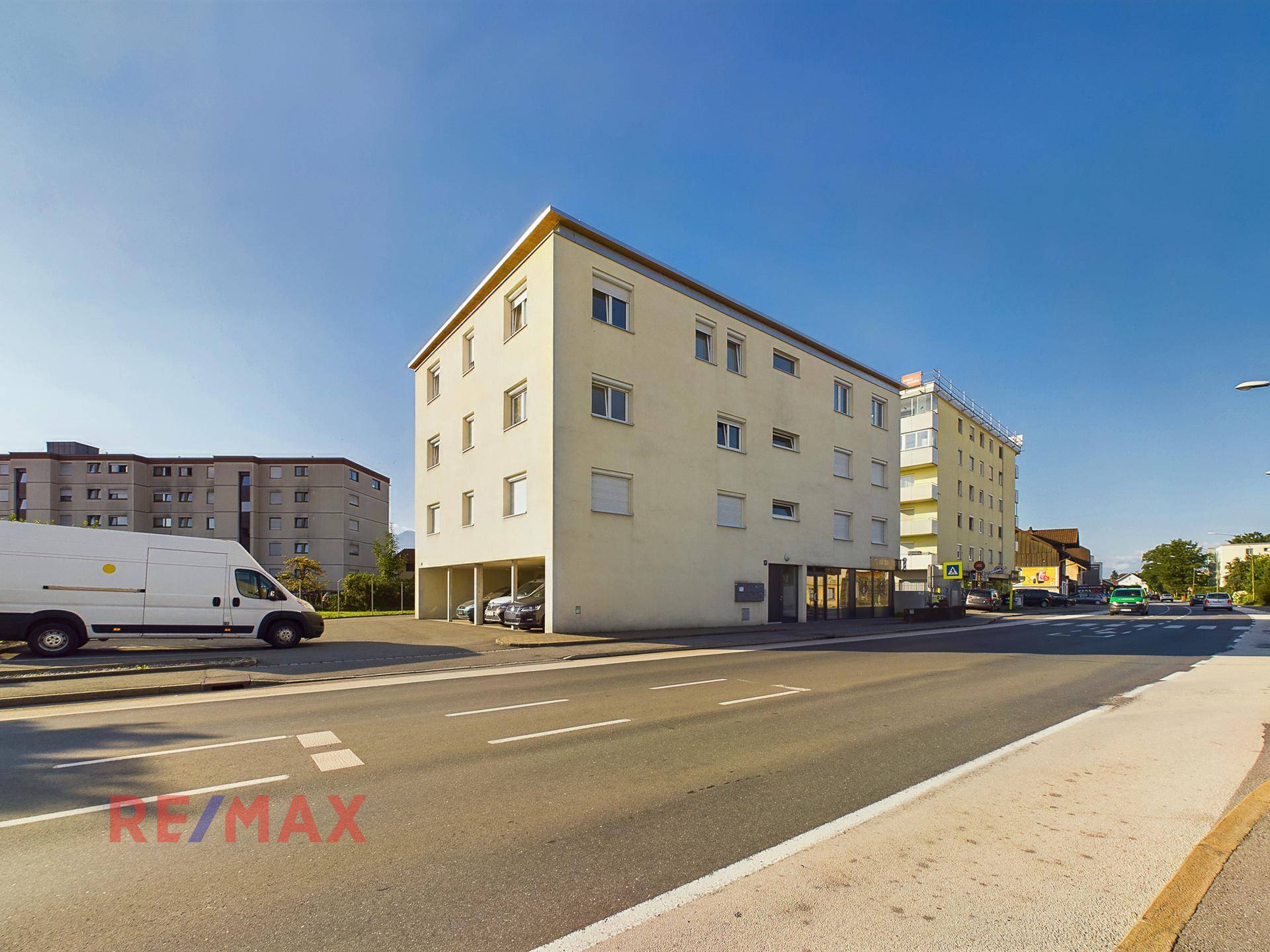 Mehrstöckiges Wohngebäude an einer Straße mit umliegender Bebauung.