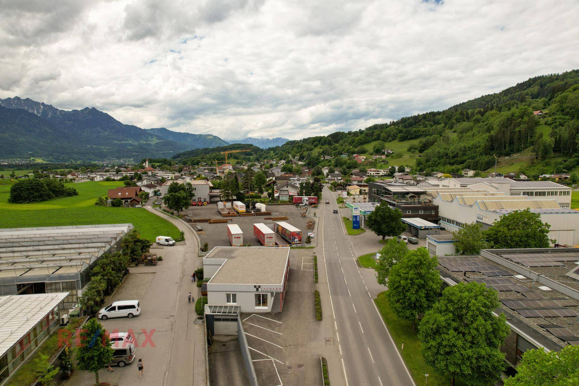 Weitläufige Luftaufnahme des Gewerbegebiets und der umliegenden Landschaft mit Wohngebäuden.