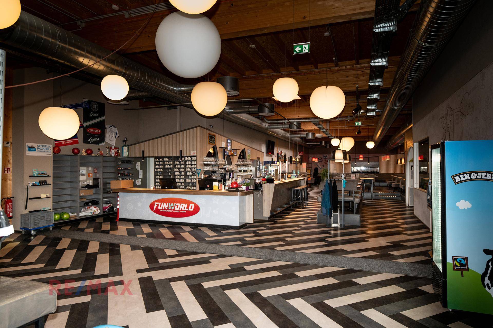 Empfangs- und Barbereich der Funworld mit moderner Theke, Sitzgelegenheiten und Deckenleuchten.