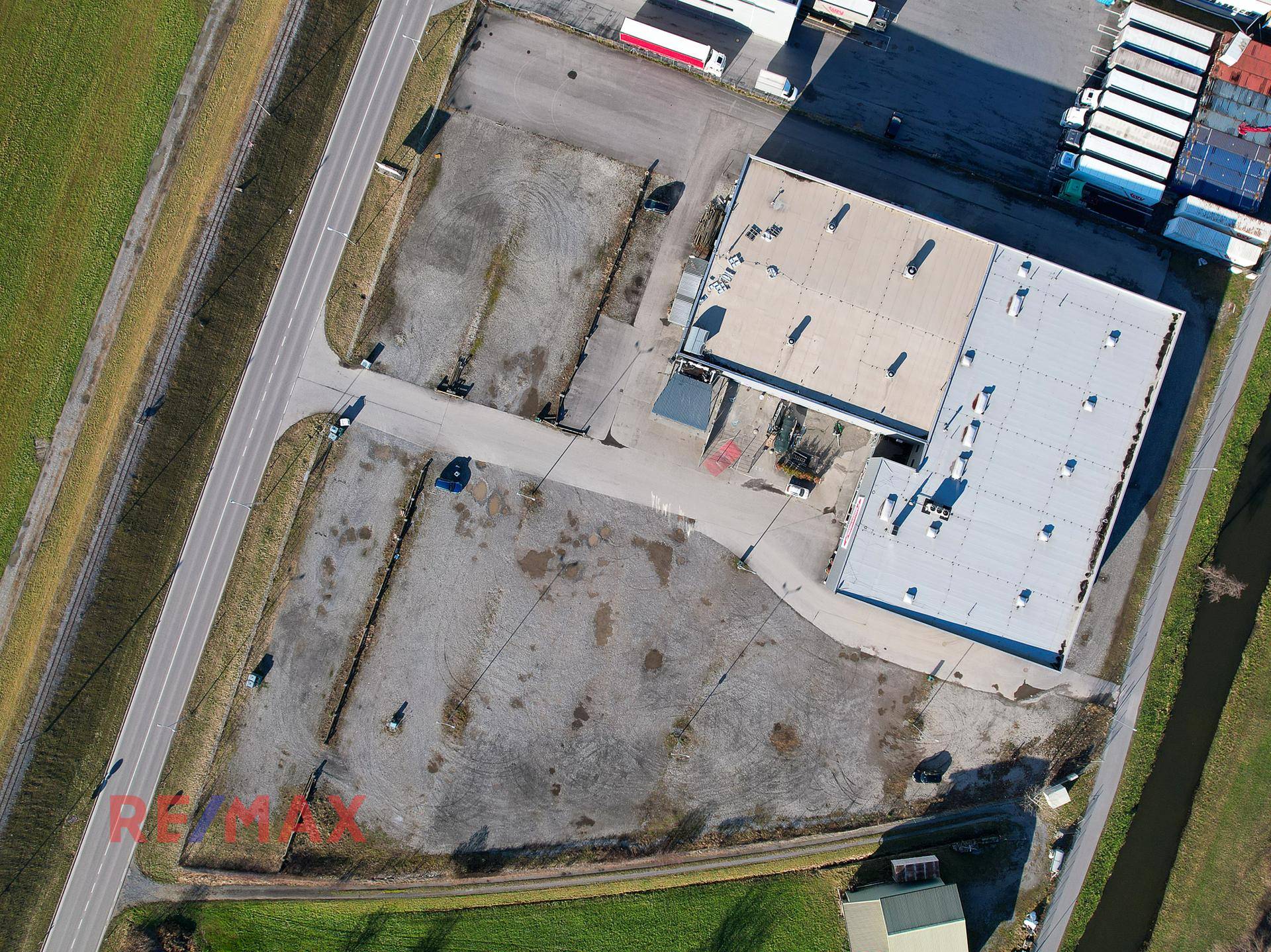 Senkrechte Luftaufnahme des Gewerbegrundstücks mit Gebäuden, Parkflächen und angrenzenden Straßen.