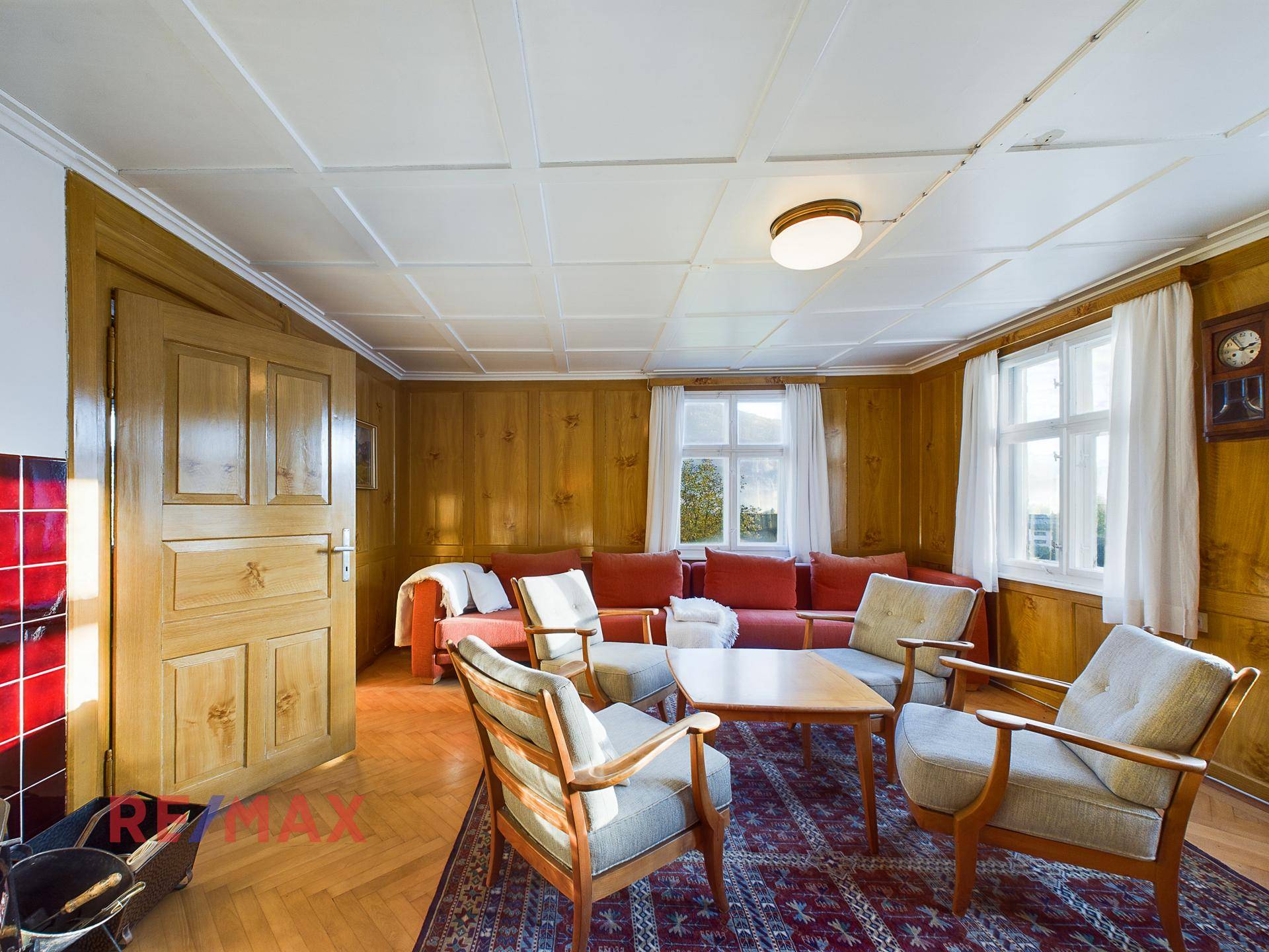 Gemütliches Wohnzimmer mit Holztäfelung, Kamin und traditionellen Sitzmöbeln.