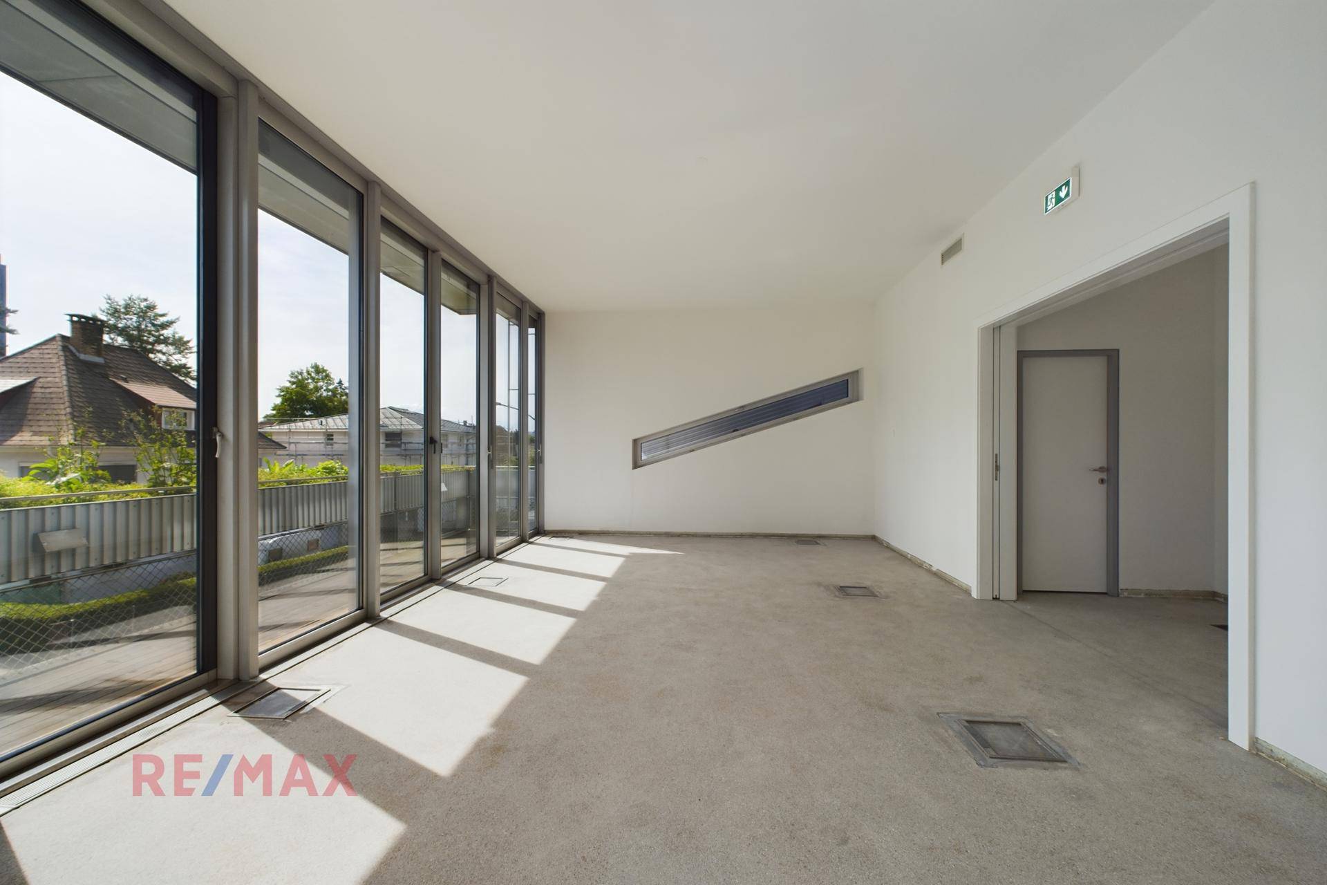 Geräumiger Büroraum mit großen Fenstern, einem schrägen Fensterdetail und viel natürlichem Licht.