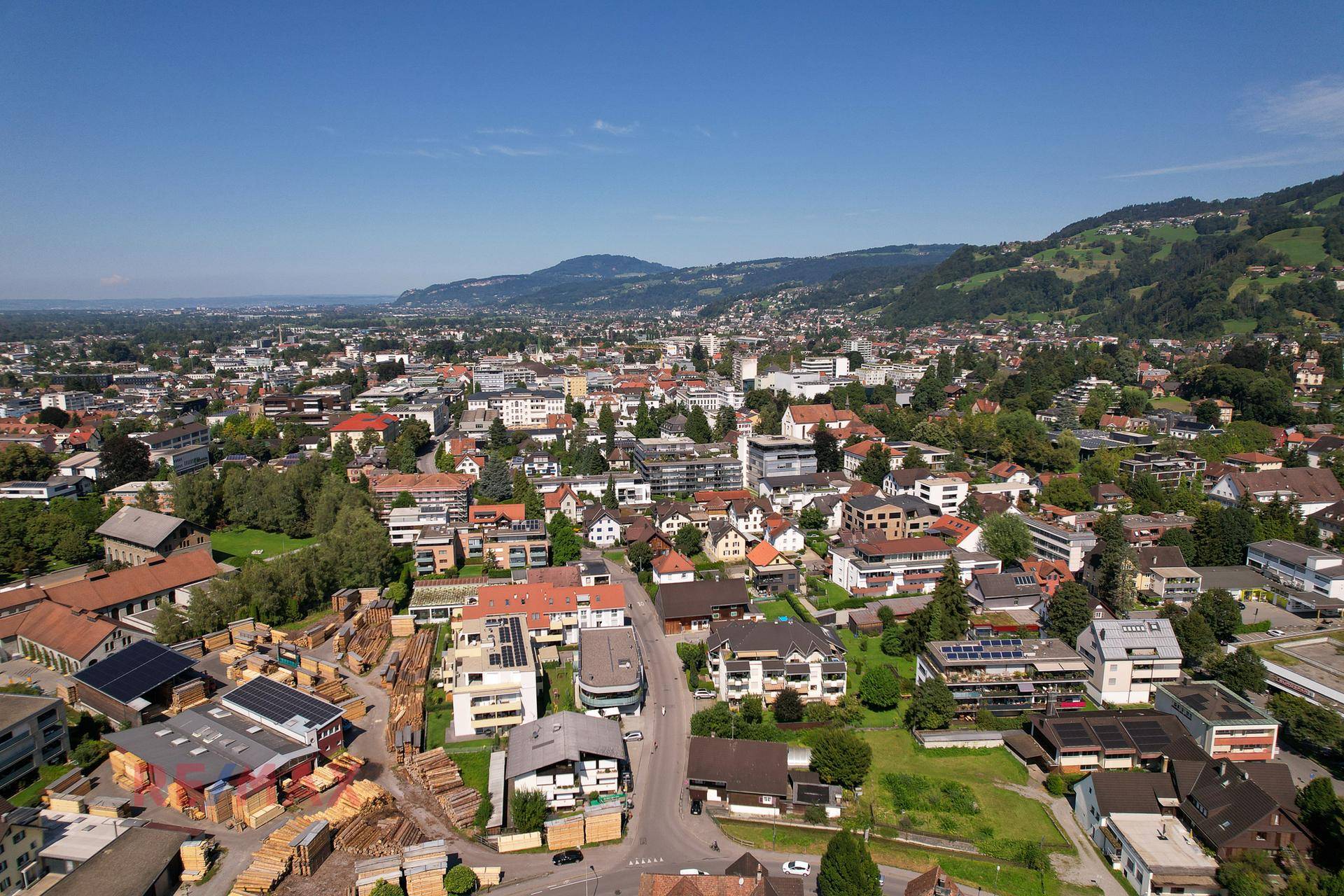 Panoramablick über die Stadt und das Tal mit weitreichender Sicht auf die umliegende Berglandschaft.