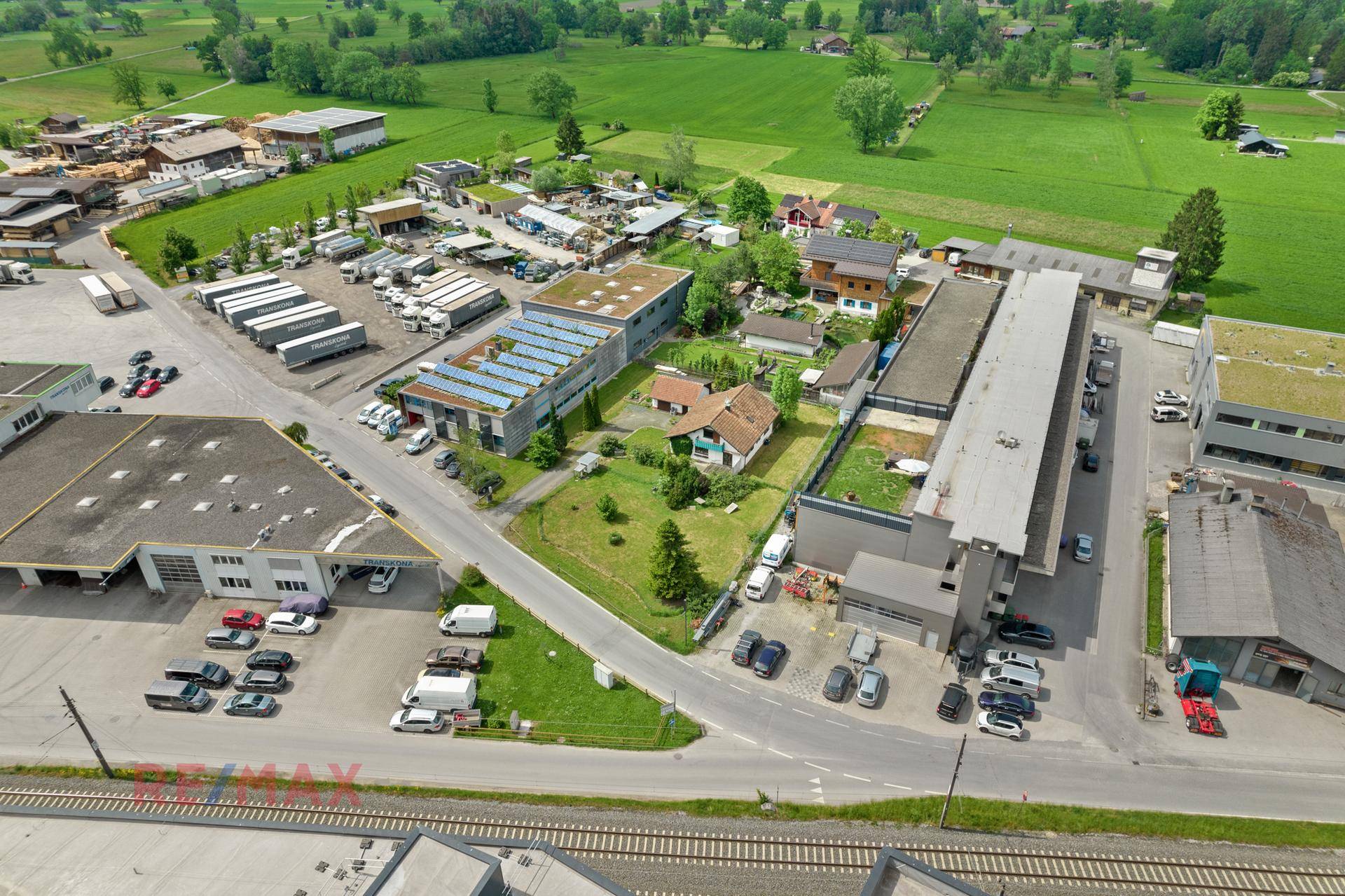 Panoramablick aus der Luft auf das Anwesen, eingebettet zwischen Gewerbegebäuden, Straßen und weiten Feldern.