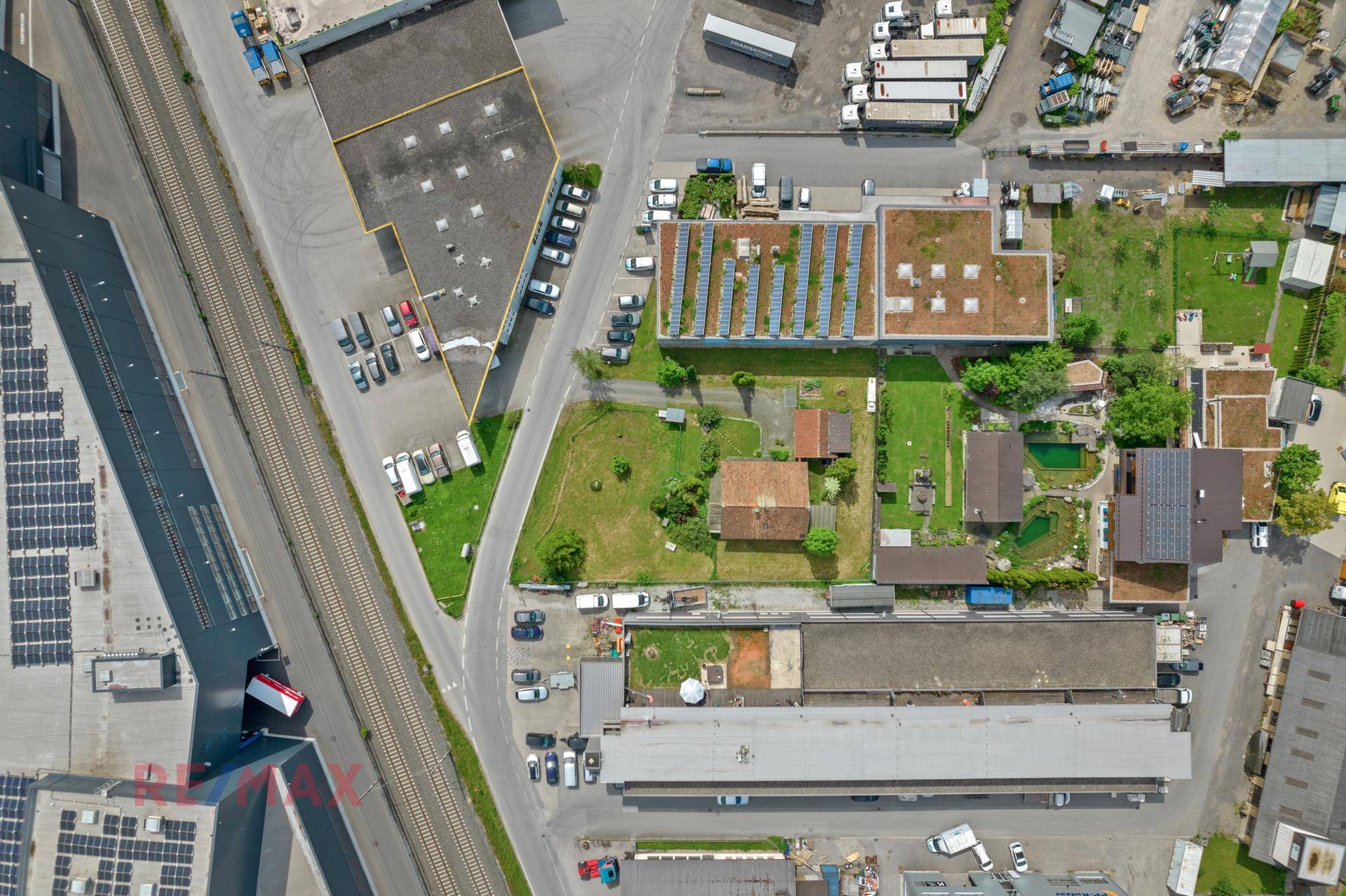Senkrechte Luftaufnahme des Anwesens, umgeben von Gewerbebauten, Straßen und Bahngleisen in der Nähe.