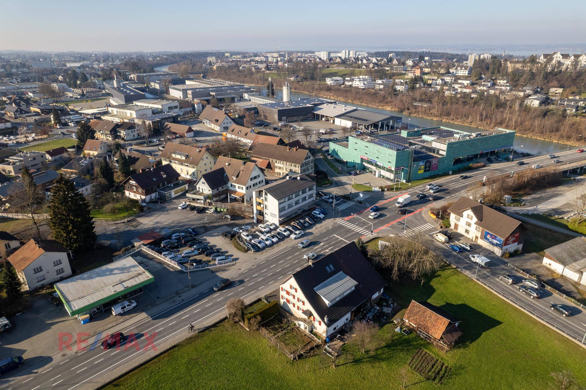 Weitläufige Luftaufnahme der Liegenschaft mit Fluss, umliegenden Gebäuden und Verkehrswegen.
