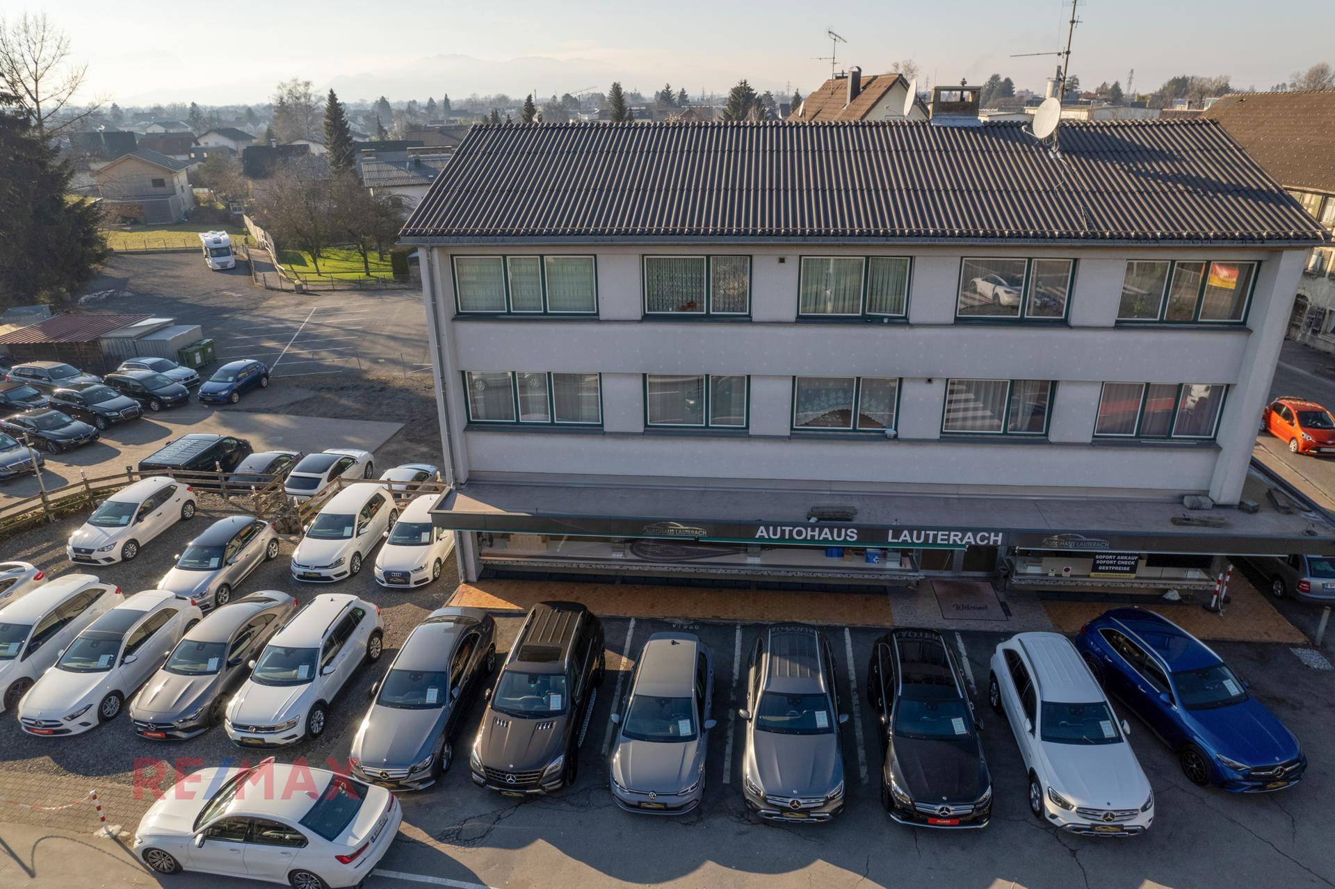 Luftaufnahme des Autohauses Lauterach mit einer großen Auswahl an Fahrzeugen auf dem Vorplatz.