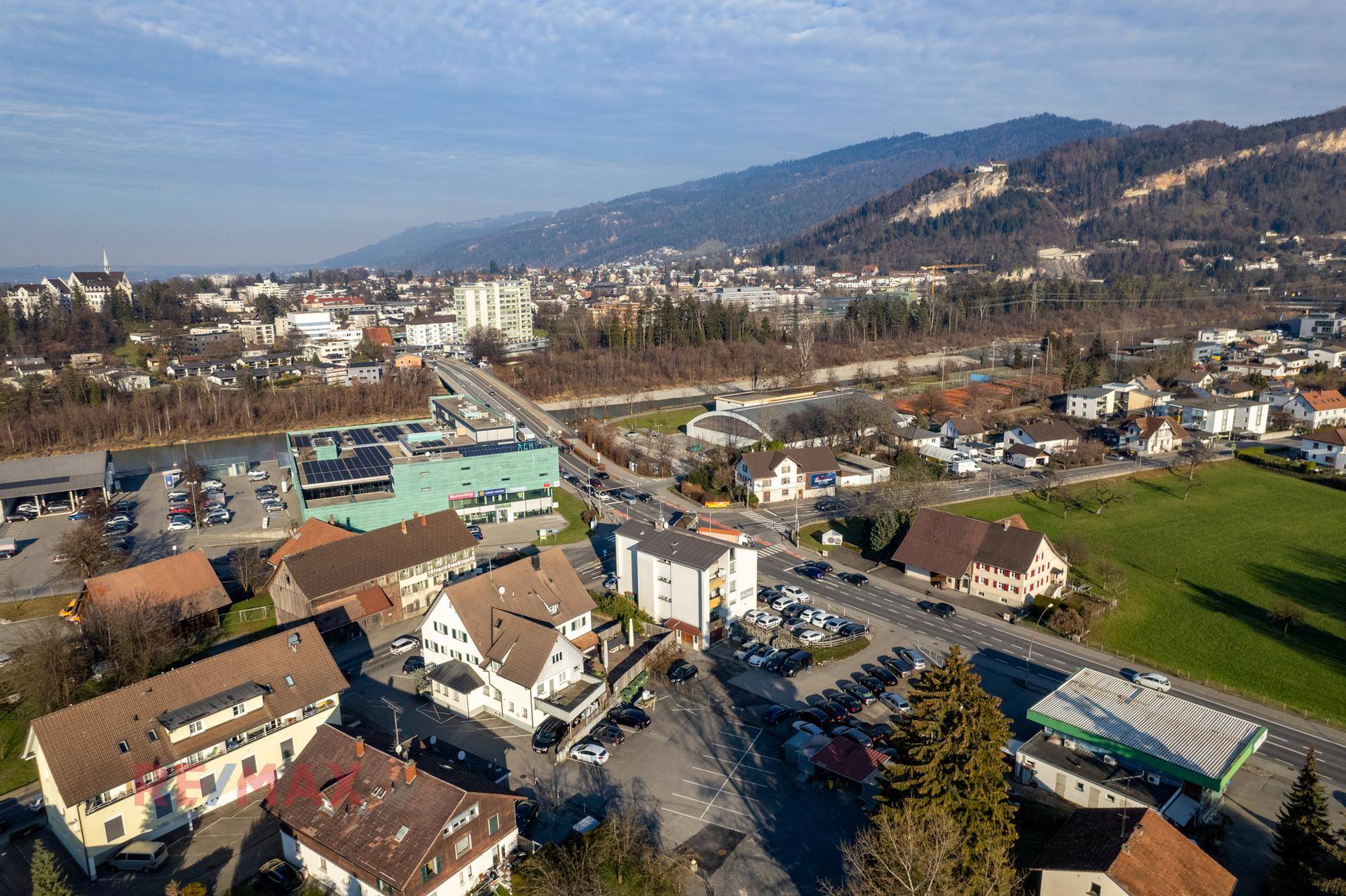 Panoramische Luftaufnahme der Immobilie mit weitem Blick über die Stadt, den Fluss und die Berge.