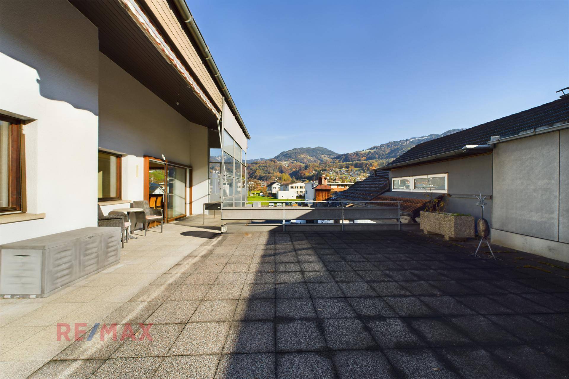 Große gepflasterte Terrasse mit viel Platz für Entspannung und Blick auf die hügelige Umgebung.