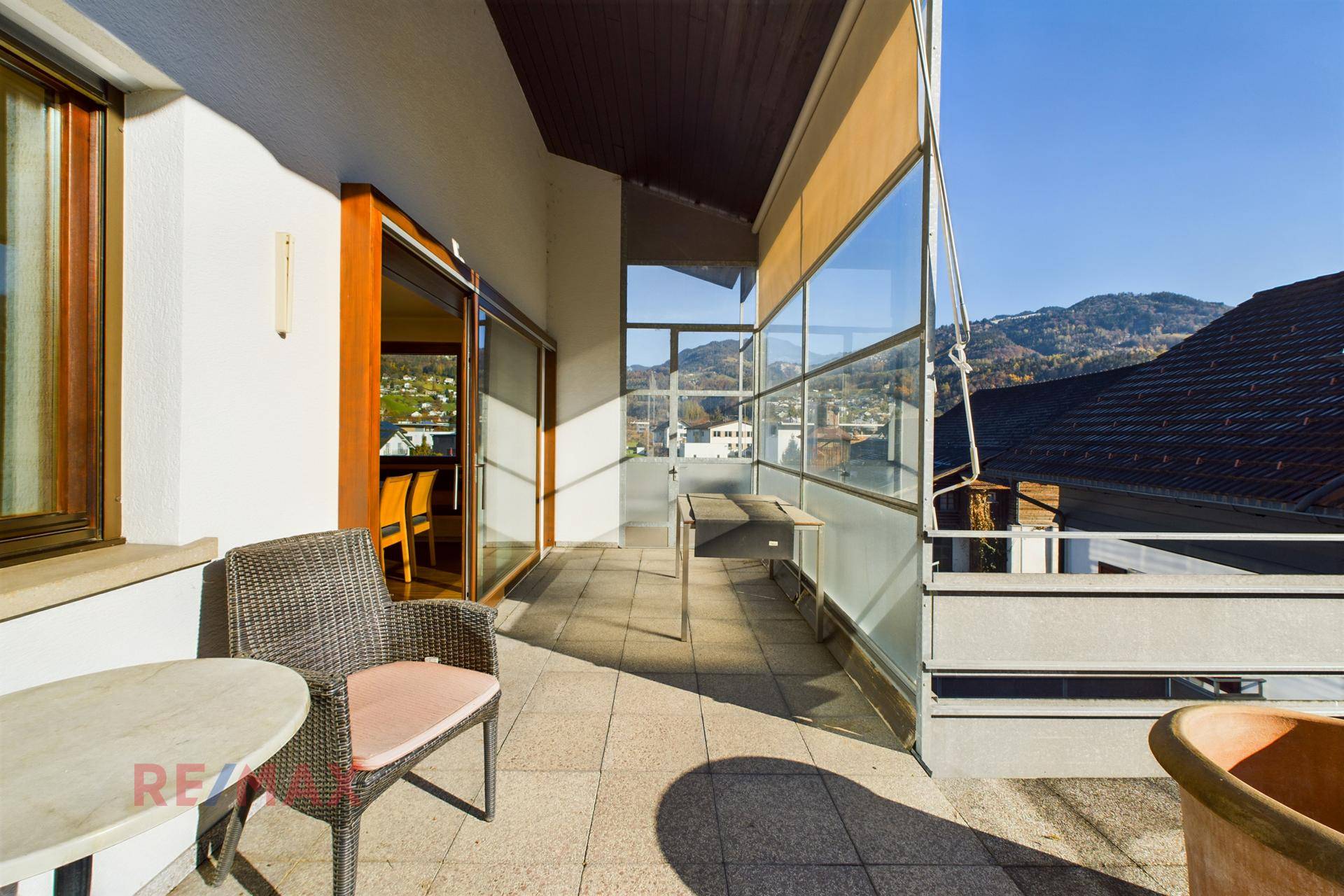 Möblierter Balkon mit Sitzgelegenheiten und weitem Blick auf die umliegende grüne Landschaft.