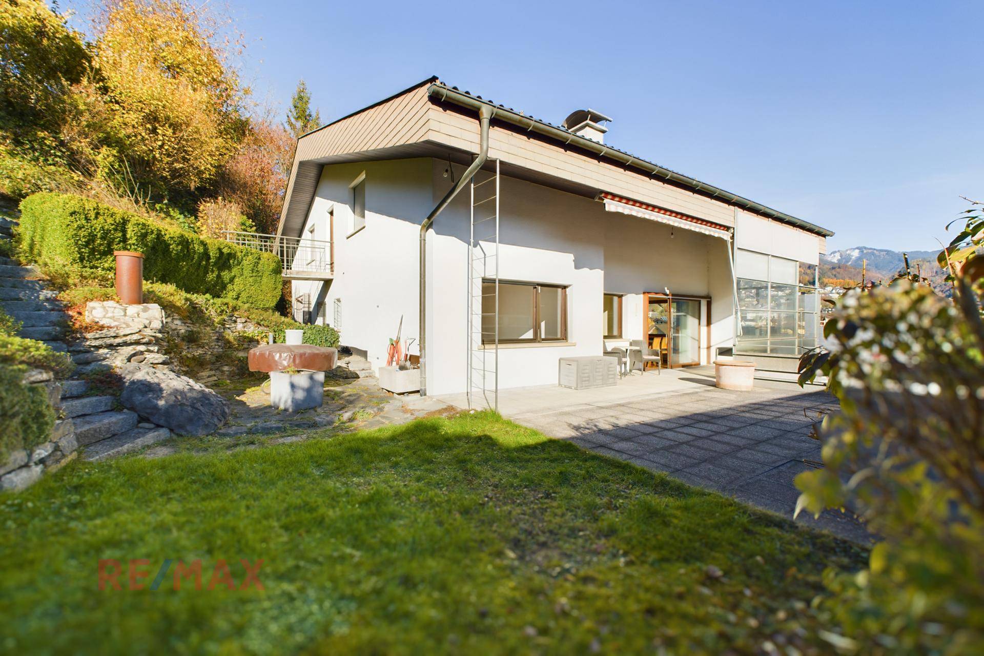 Rückseite des Hauses mit Terrasse und Zugang zum terrassierten Gartenbereich.