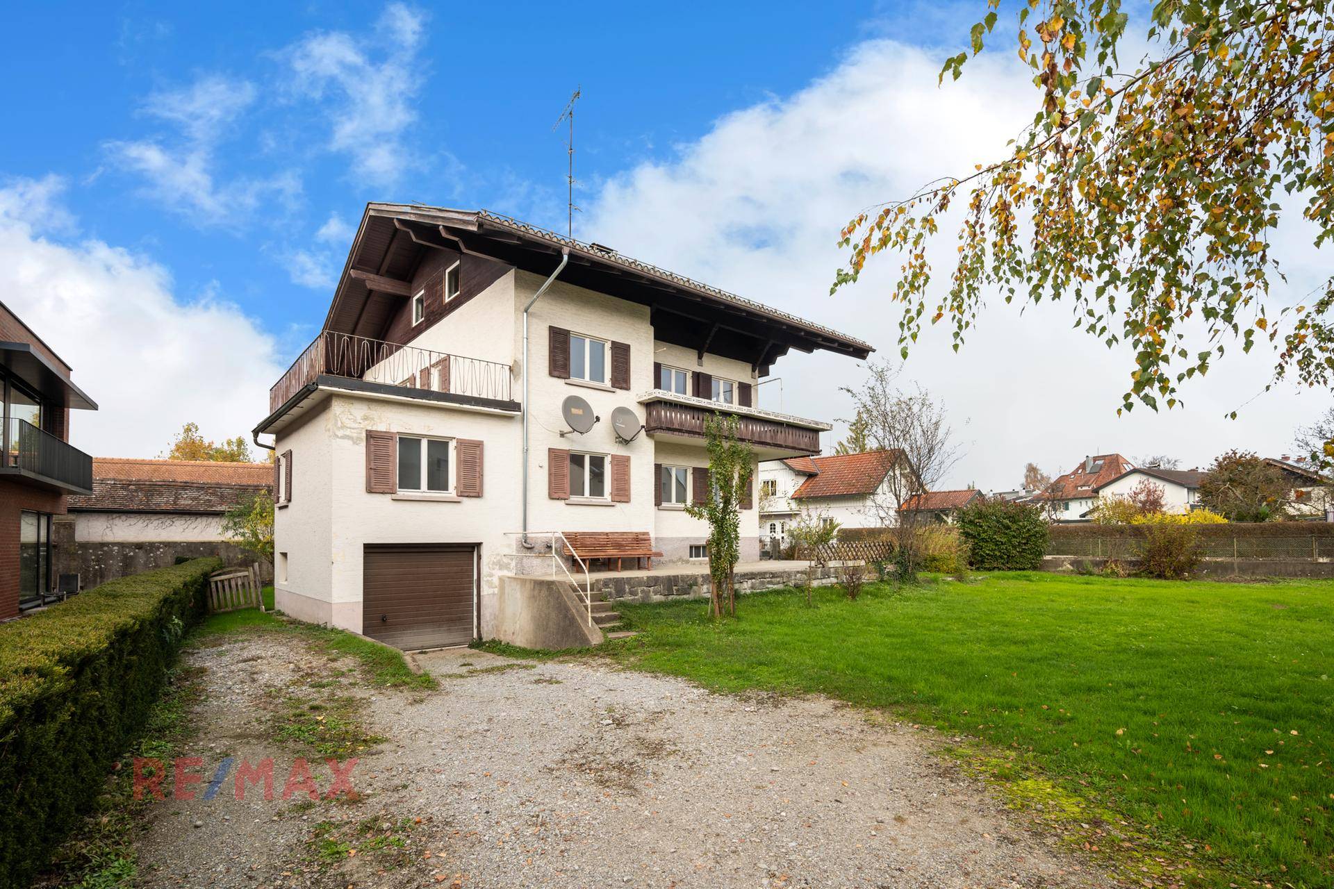Rückansicht des Hauses mit Garage, Zufahrt und großem Gartenbereich.