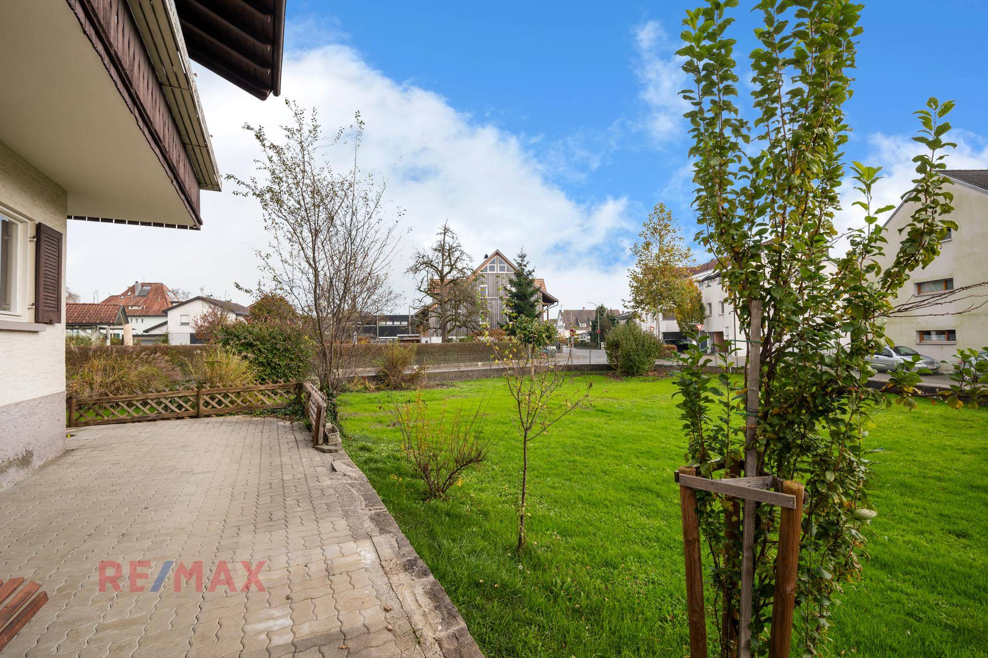 Terrasse mit Zugang zum grünen Garten und Blick auf die Nachbarschaft.