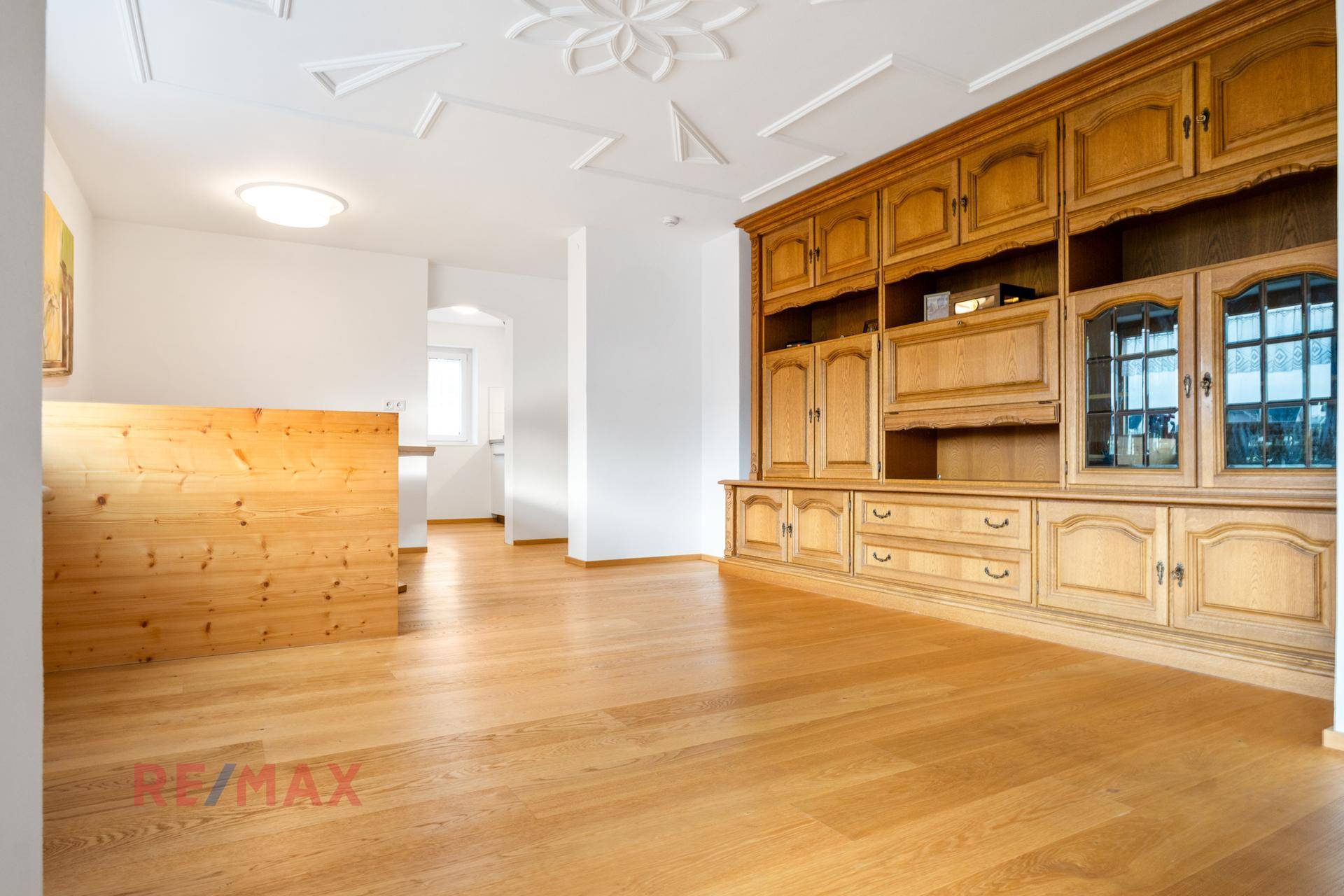 Essbereich mit großer Holzschrankwand und Blick in den angrenzenden Wohnbereich.