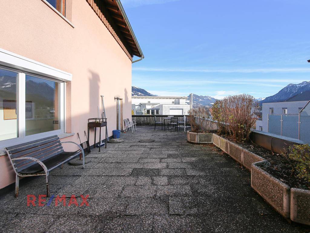 Große Terrasse mit Sitzbank und weitem Blick auf die umliegende Berglandschaft.