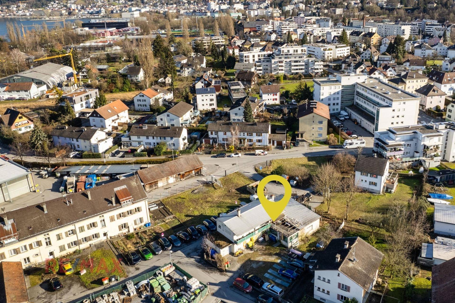 Luftaufnahme der Immobilie im städtischen Umfeld mit Blick auf die umliegende Bebauung und den See.