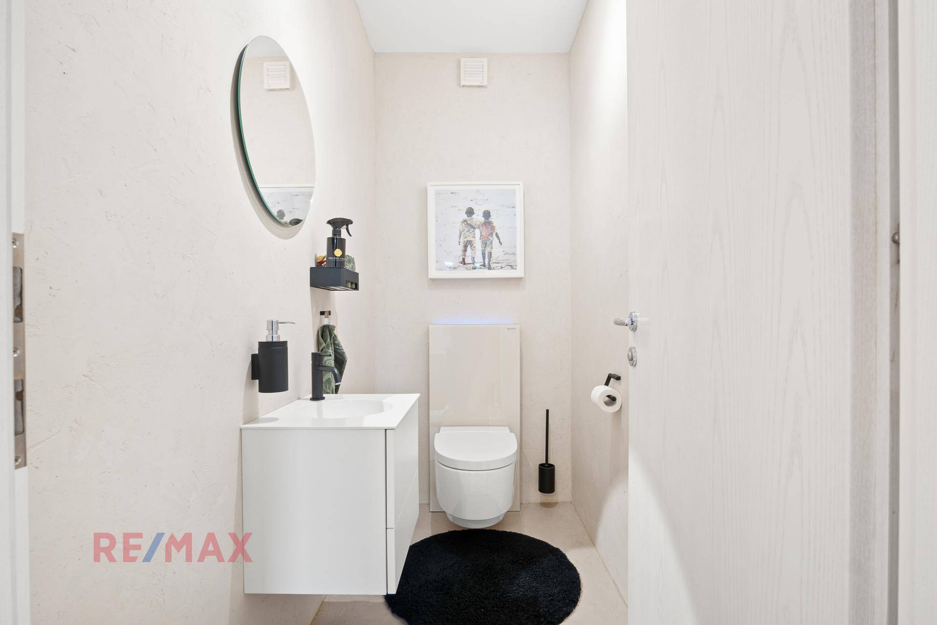 Modernes Gäste-WC mit wandhängendem WC, Einzelwaschbecken und minimalistischem Design.