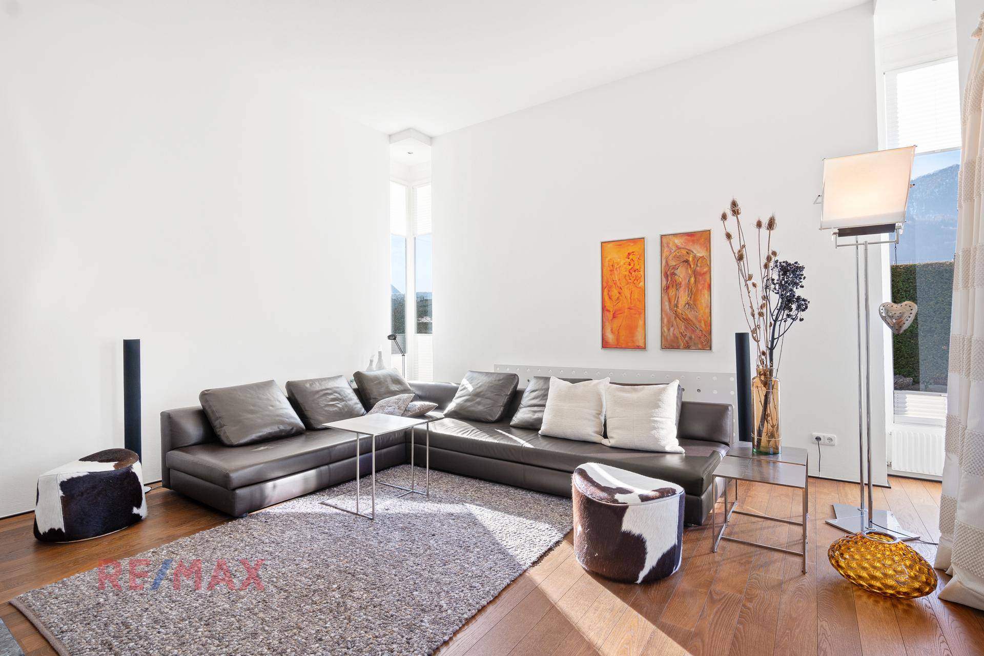 Gemütliches Wohnzimmer mit großem Ecksofa, Holzboden und moderner Dekoration.