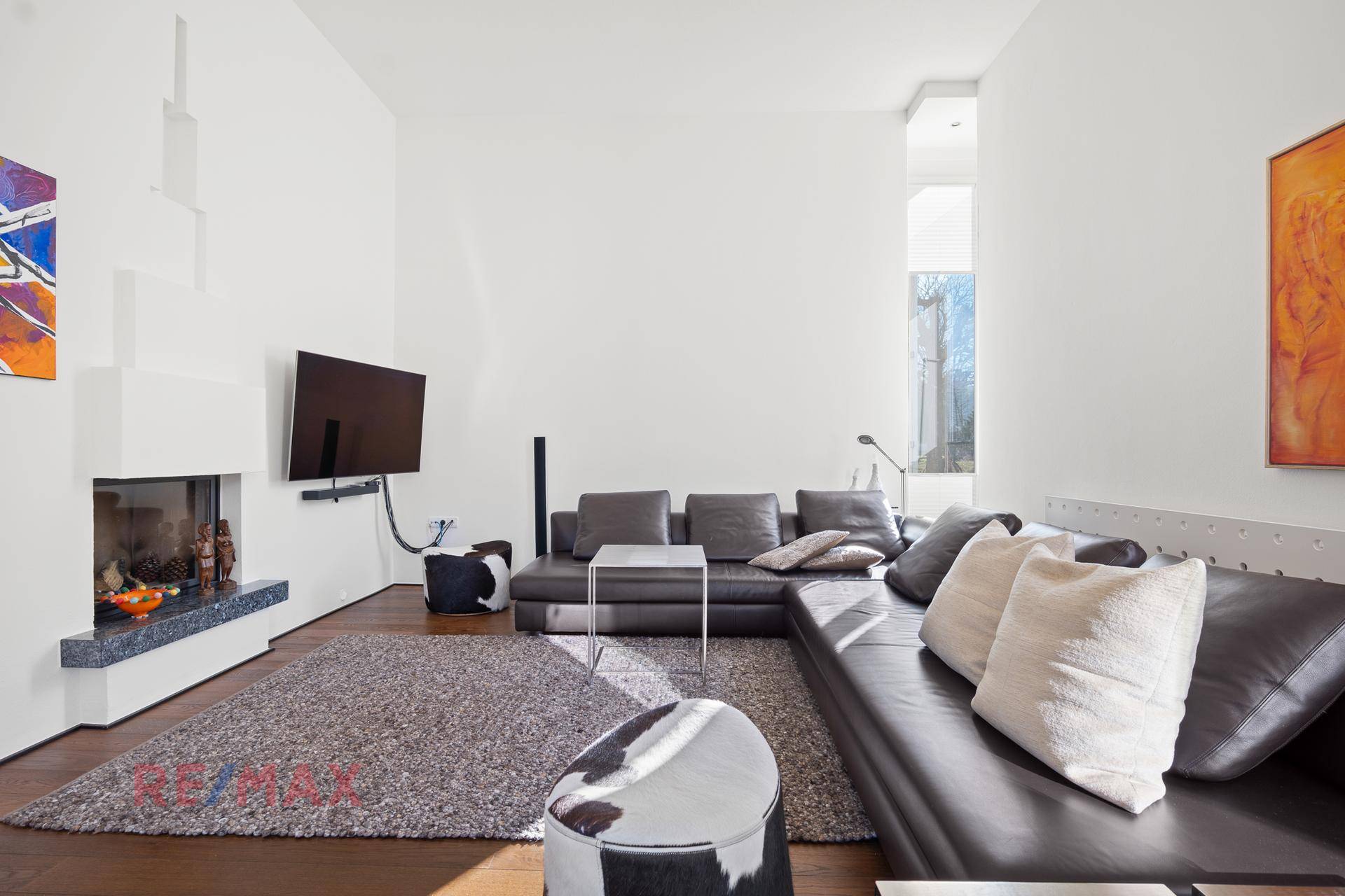 Helles Wohnzimmer mit Kamin, Holzboden und großem Ecksofa für entspannte Abende.