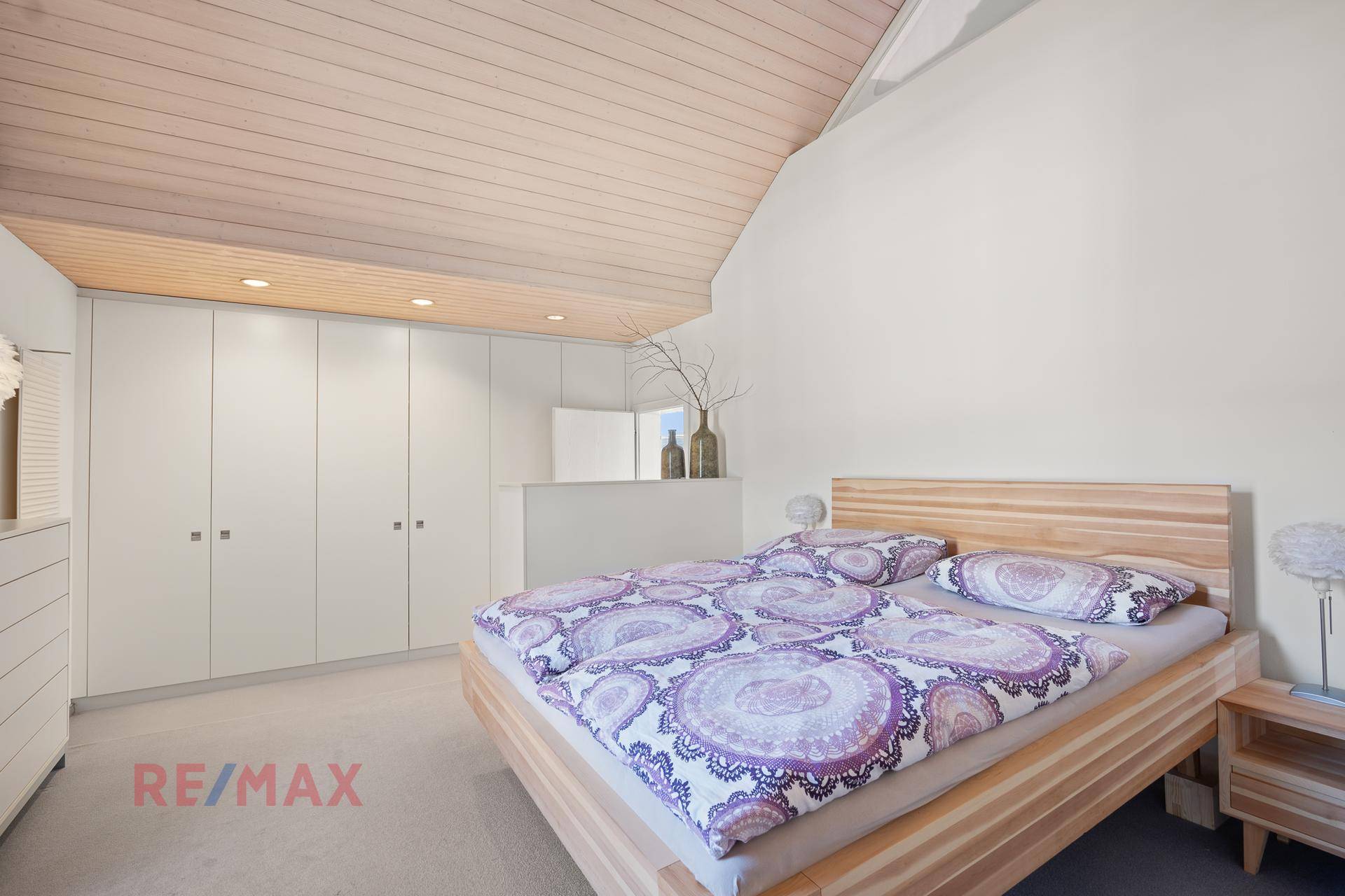 Geräumiges Schlafzimmer mit Einbauschränken, Holzbett und gemütlicher Atmosphäre.